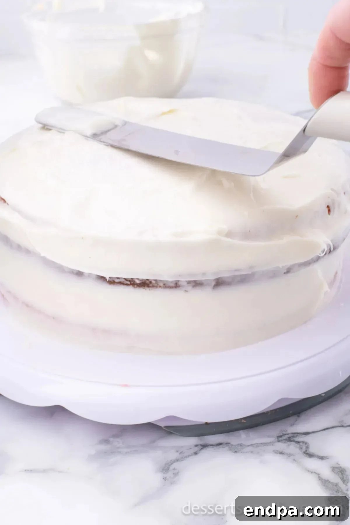 Decadent Strawberry Shortcake Cheesecake 13 The cheesecake layer being carefully placed onto the frosted strawberry cake layer.