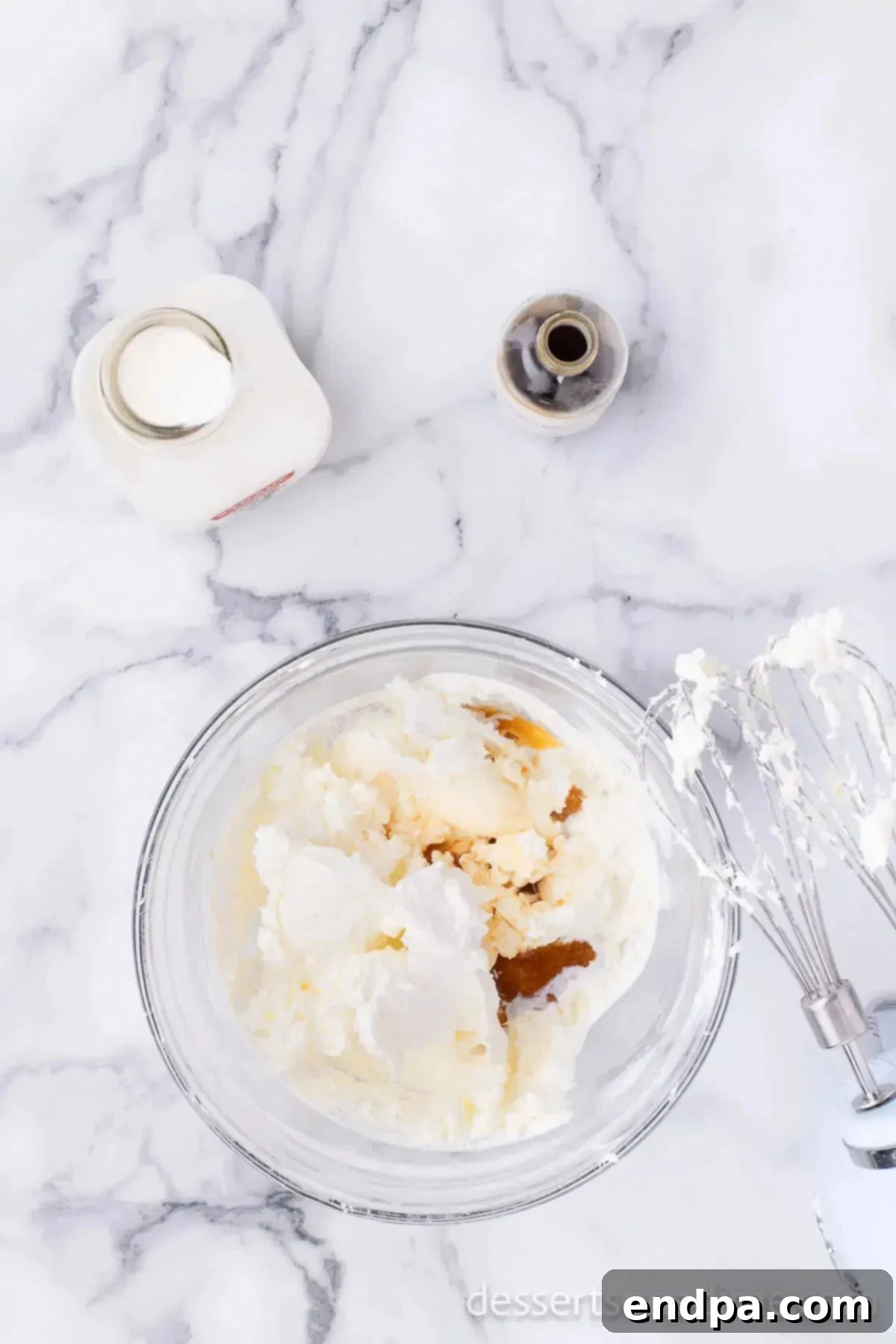 Decadent Strawberry Shortcake Cheesecake 6 Cream cheese mixture in a mixing bowl, smooth and ready for the next ingredients.
