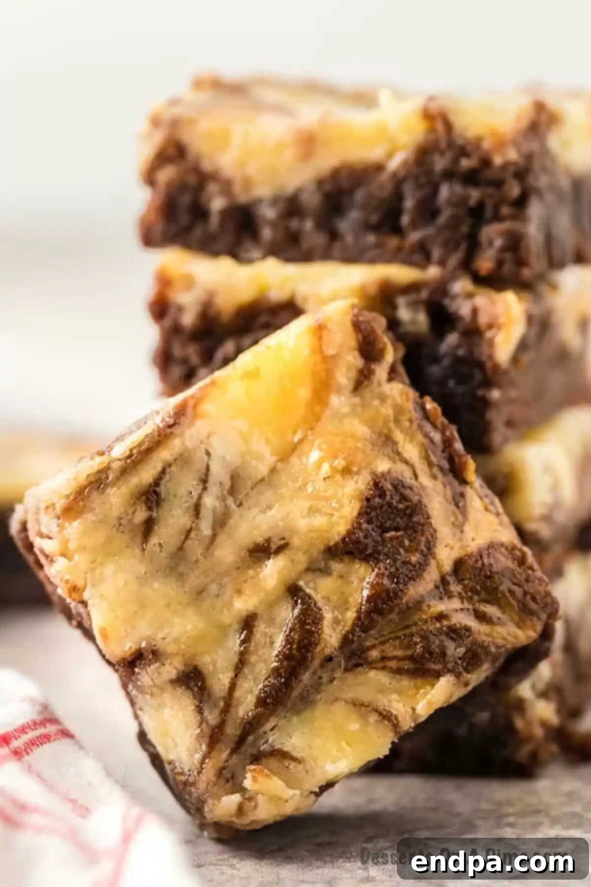 Freshly baked cream cheese brownies cut into perfect squares, showcasing the elegant cream cheese swirls.