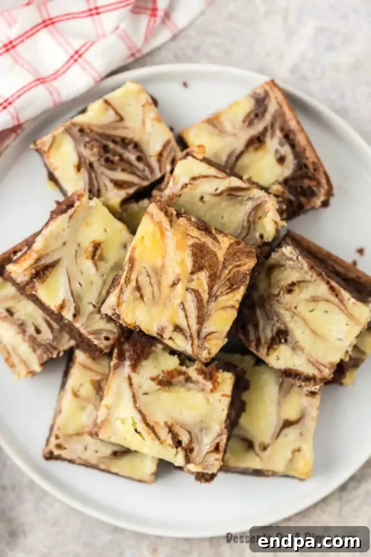 Close-up of cream cheese brownies, neatly sliced to show the distinct chocolate and cheesecake layers.