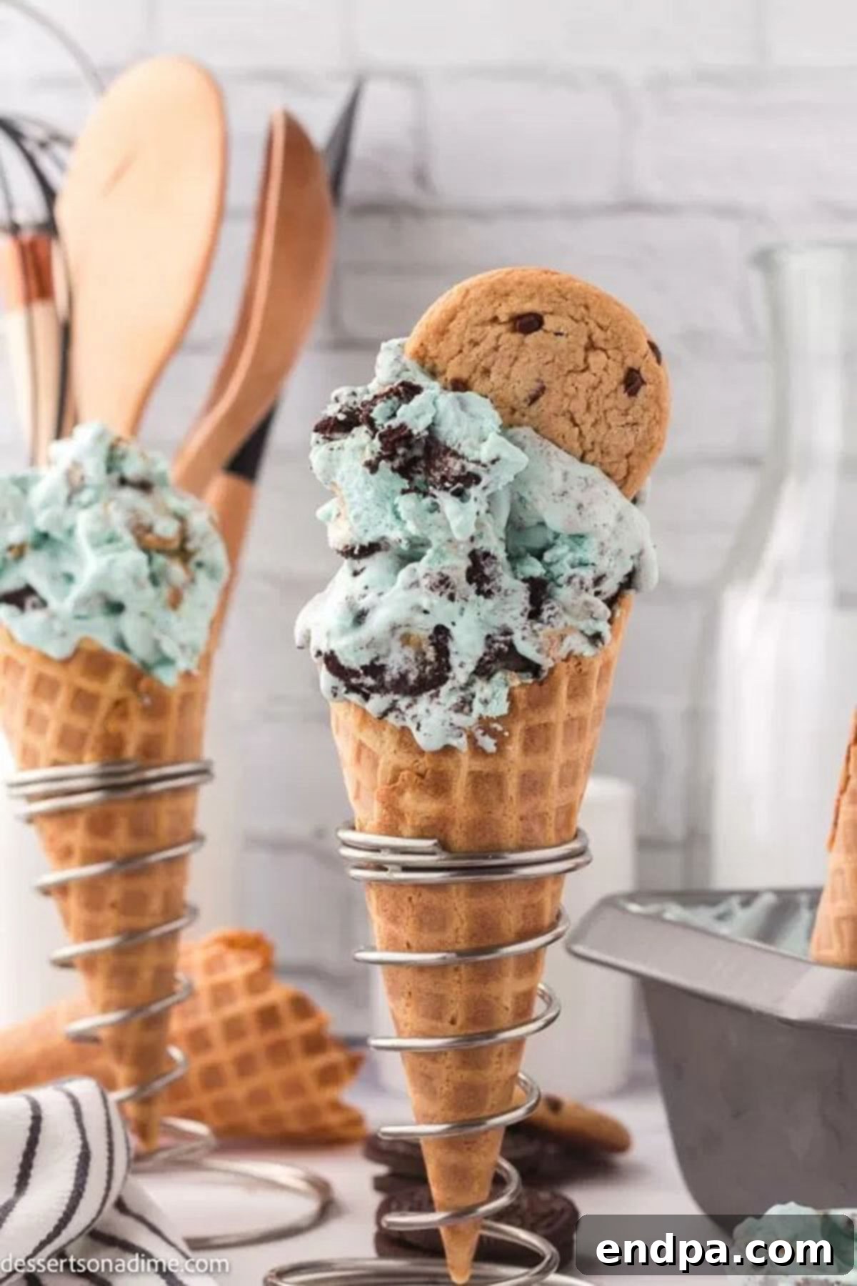Scoops of Cookie Monster Ice Cream served in classic ice cream cones.