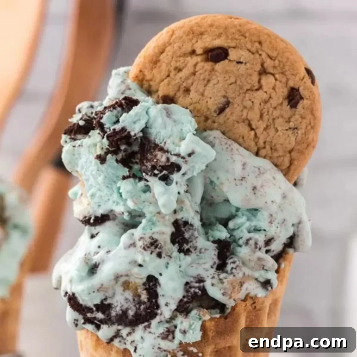 Scoops of vibrant blue Cookie Monster Ice Cream in a waffle cone, ready to eat.