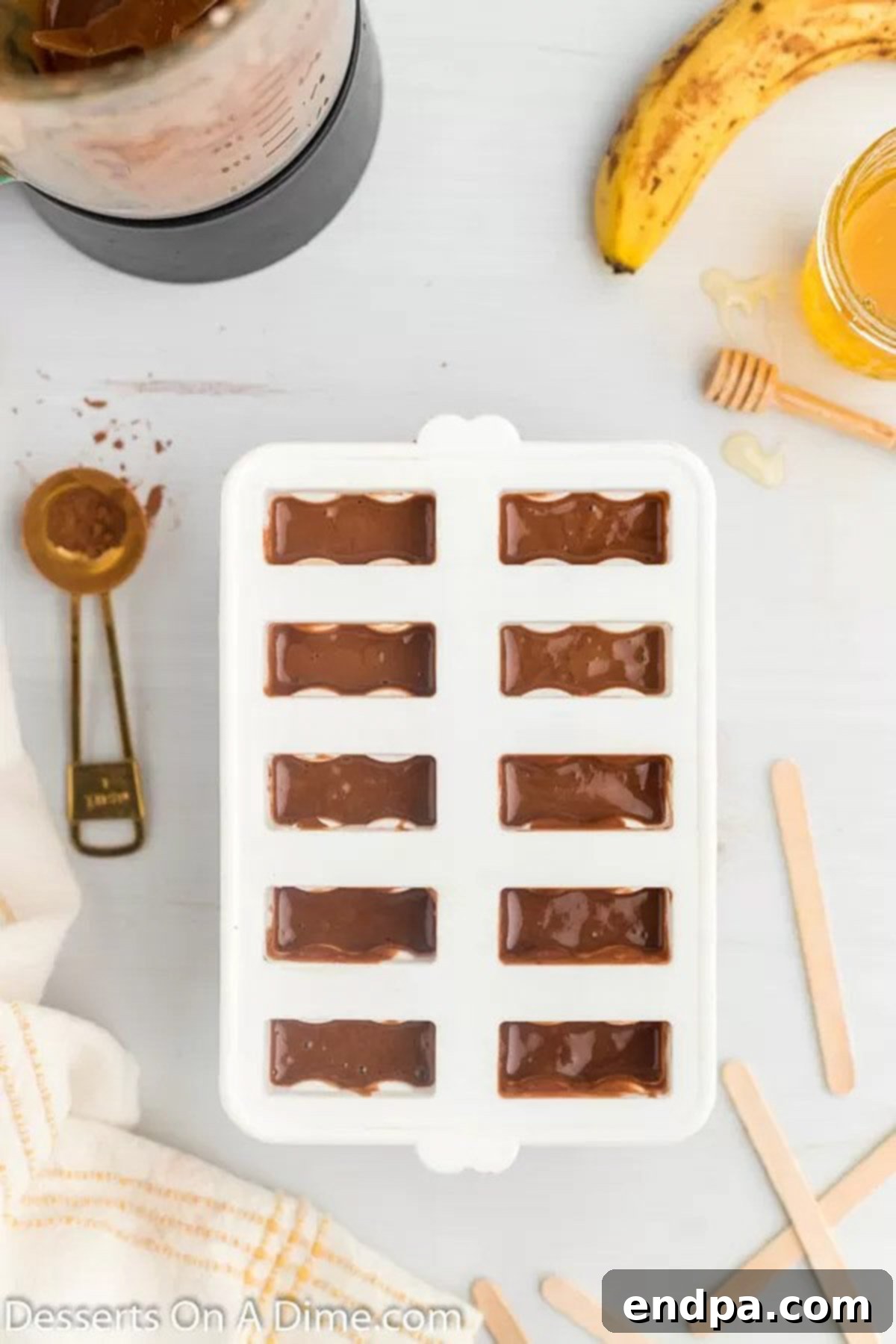 Popsicle molds filled with the chocolate banana mixture, ready for freezing.