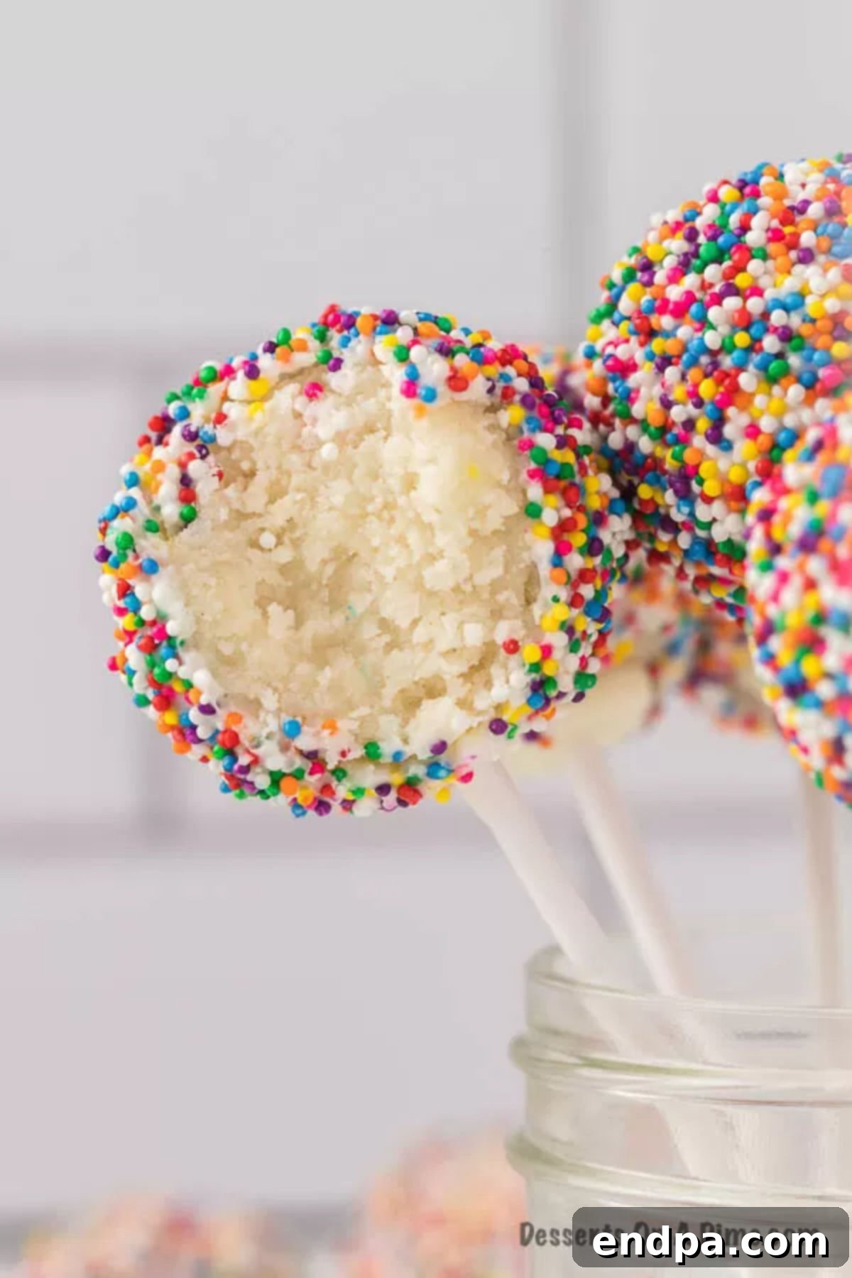 Close up photo of beautifully decorated birthday cake pops with vibrant sprinkles.