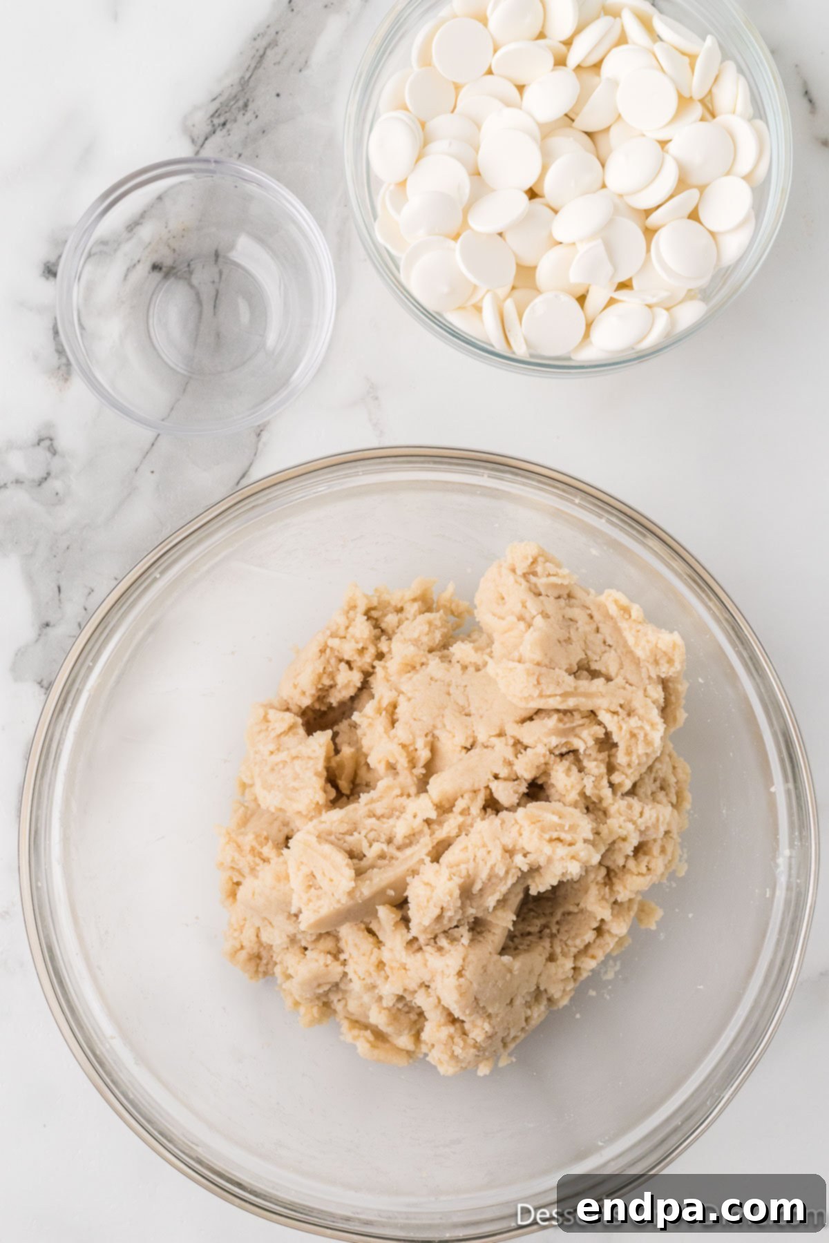 Crumbled cake and frosting thoroughly combined in a bowl, forming a dough-like mixture.