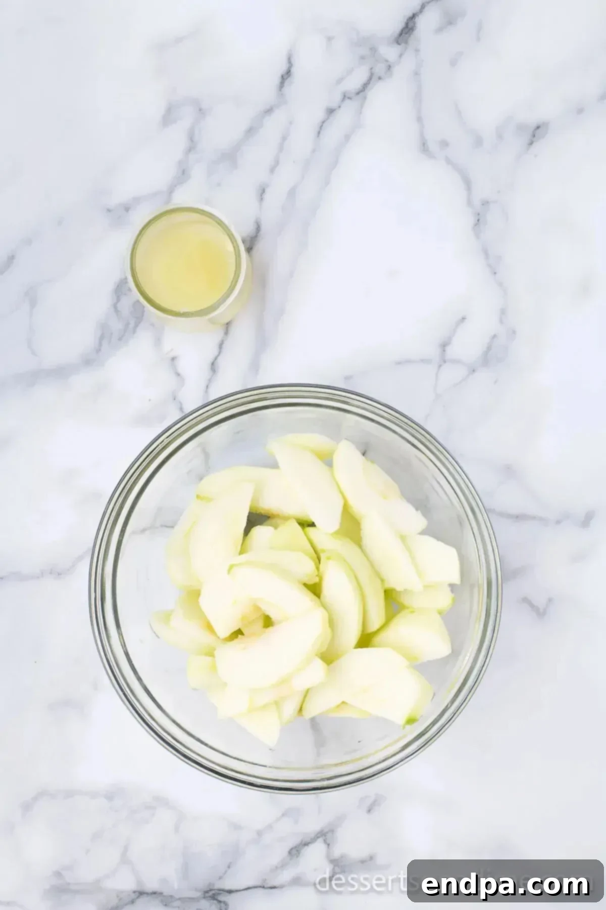 Bowl of apple slices coated with lemon juice.