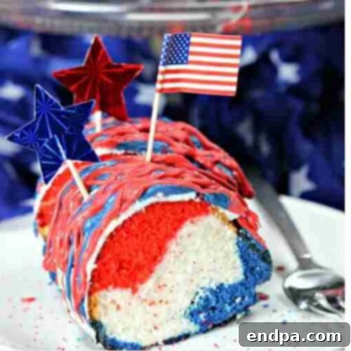 A slice of Red, White, and Blue Layer Cake on a plate, showing the swirled colors.