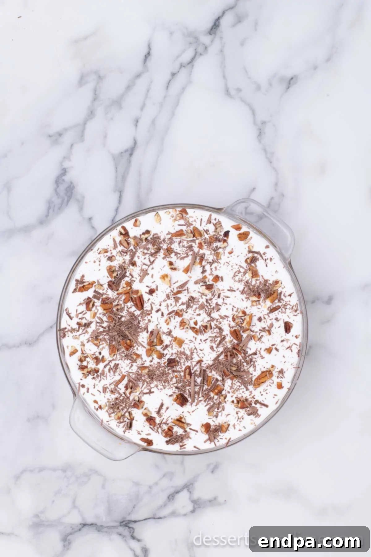 The finished Arkansas Possum Pie, generously topped with whipped cream, chopped pecans, and elegant chocolate shavings.