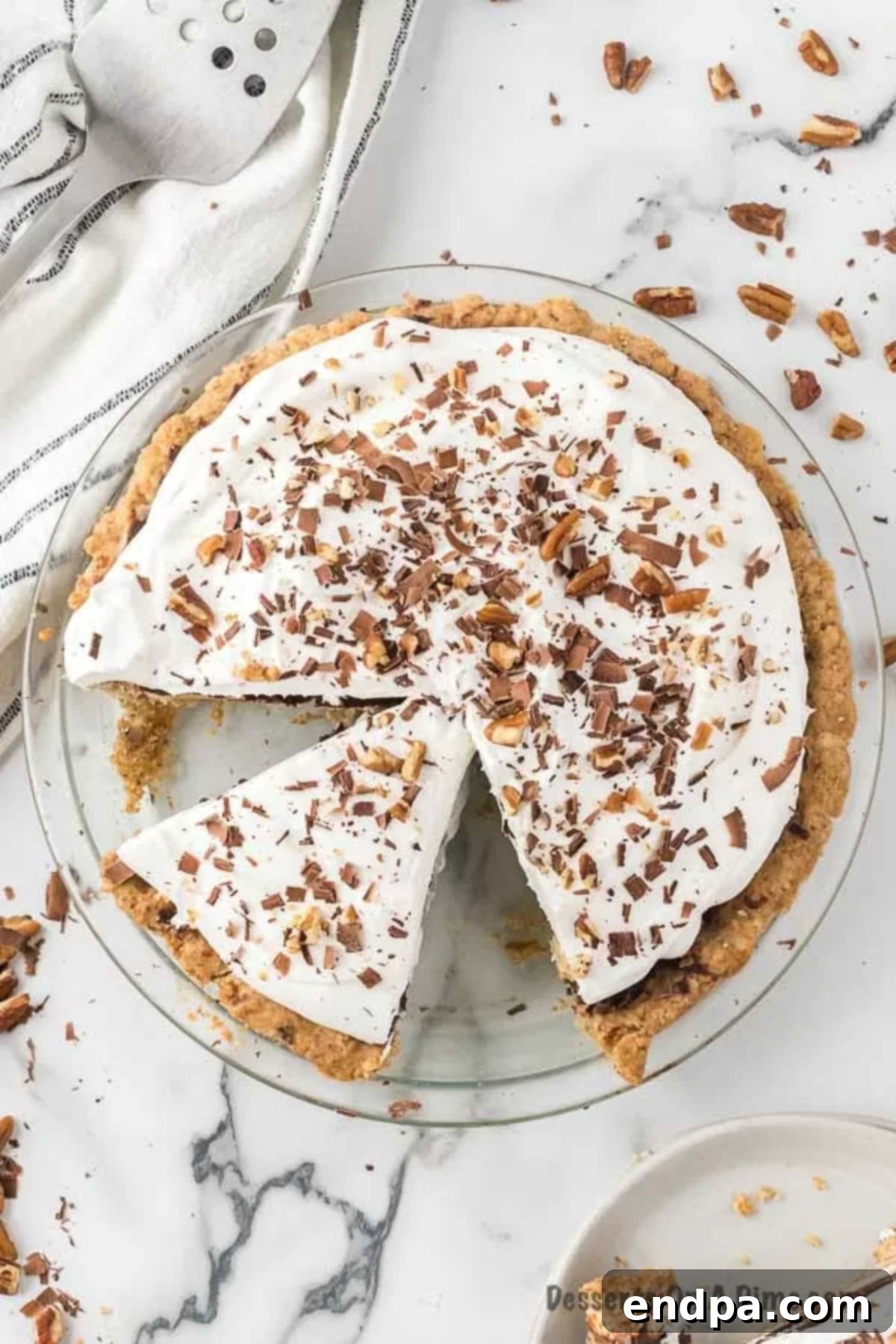 A close-up of a Possum Pie, with several slices already cut, revealing the distinct layers of crust, cream cheese, chocolate pudding, and whipped topping.