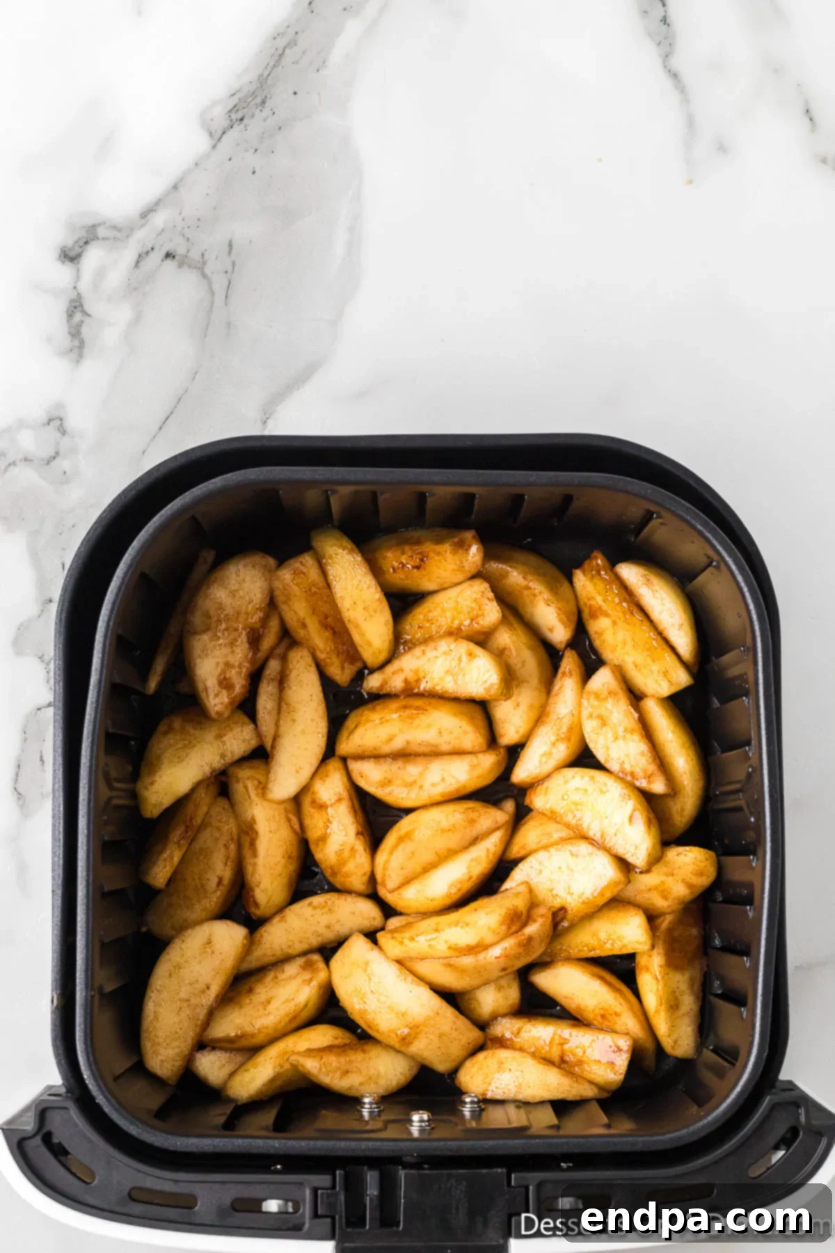 Golden Air Fryer Apple Slices 6 Apples in air fryer basket.