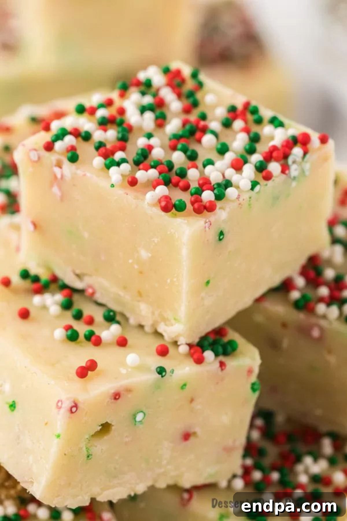 Delicious Sugar Cookie Fudge bars topped with colorful sprinkles, cut into perfect squares, ready to be enjoyed.