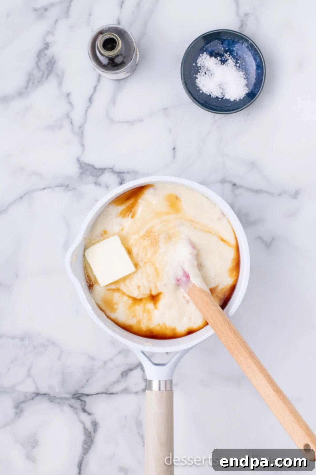 Saucepan with sweetened condensed milk warming gently on the stove over medium-high heat.