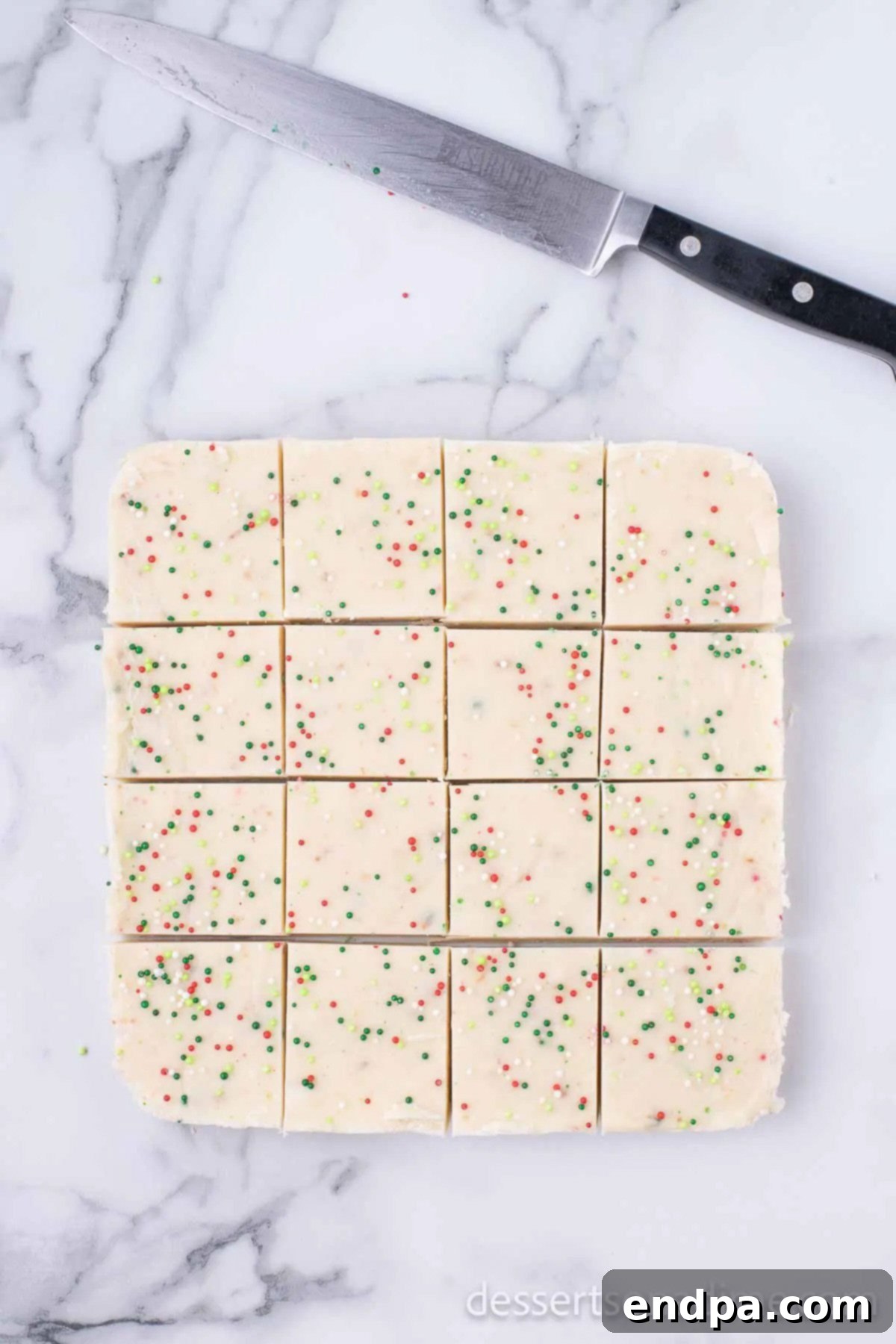 Set Sugar Cookie Fudge meticulously cut into small, uniform squares on a cutting board, ready for serving.