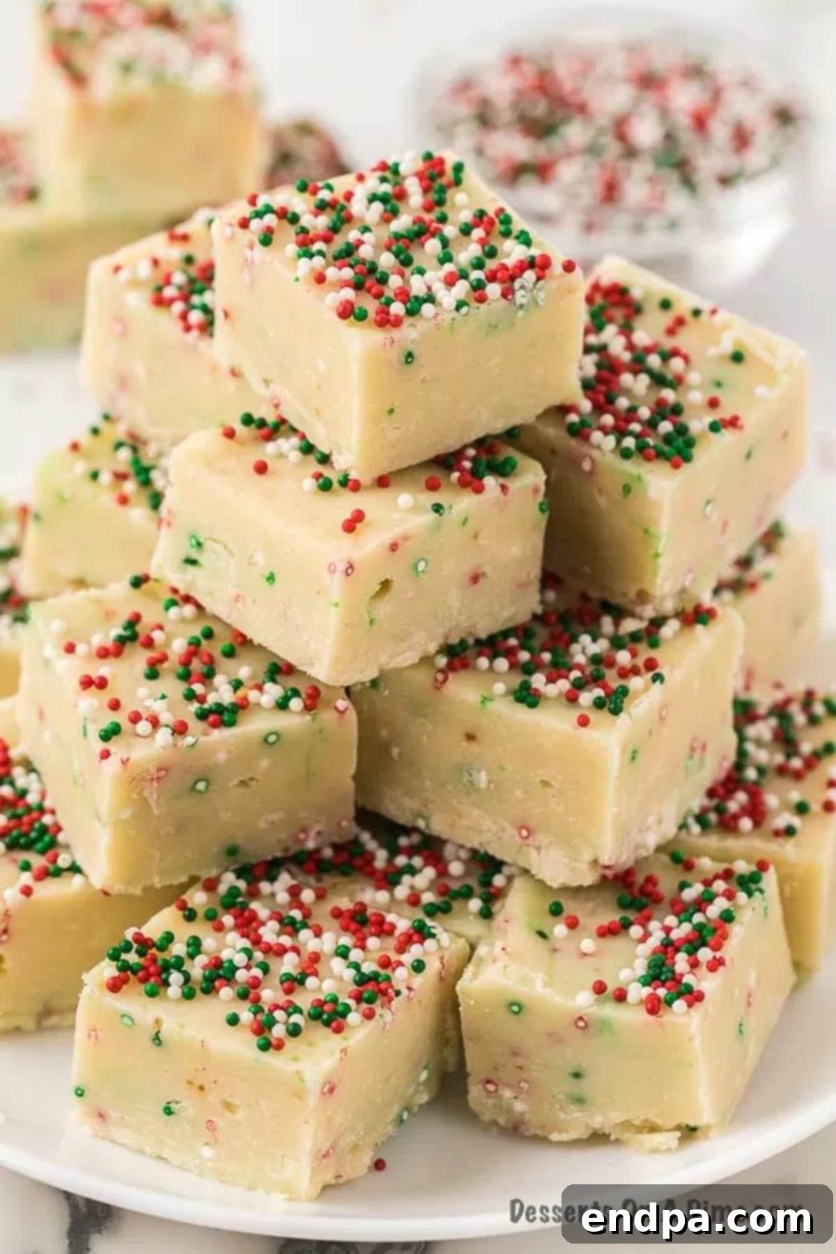 Close-up of freshly cut Sugar Cookie Fudge squares, showcasing the creamy texture, vibrant sprinkles, and perfect consistency.