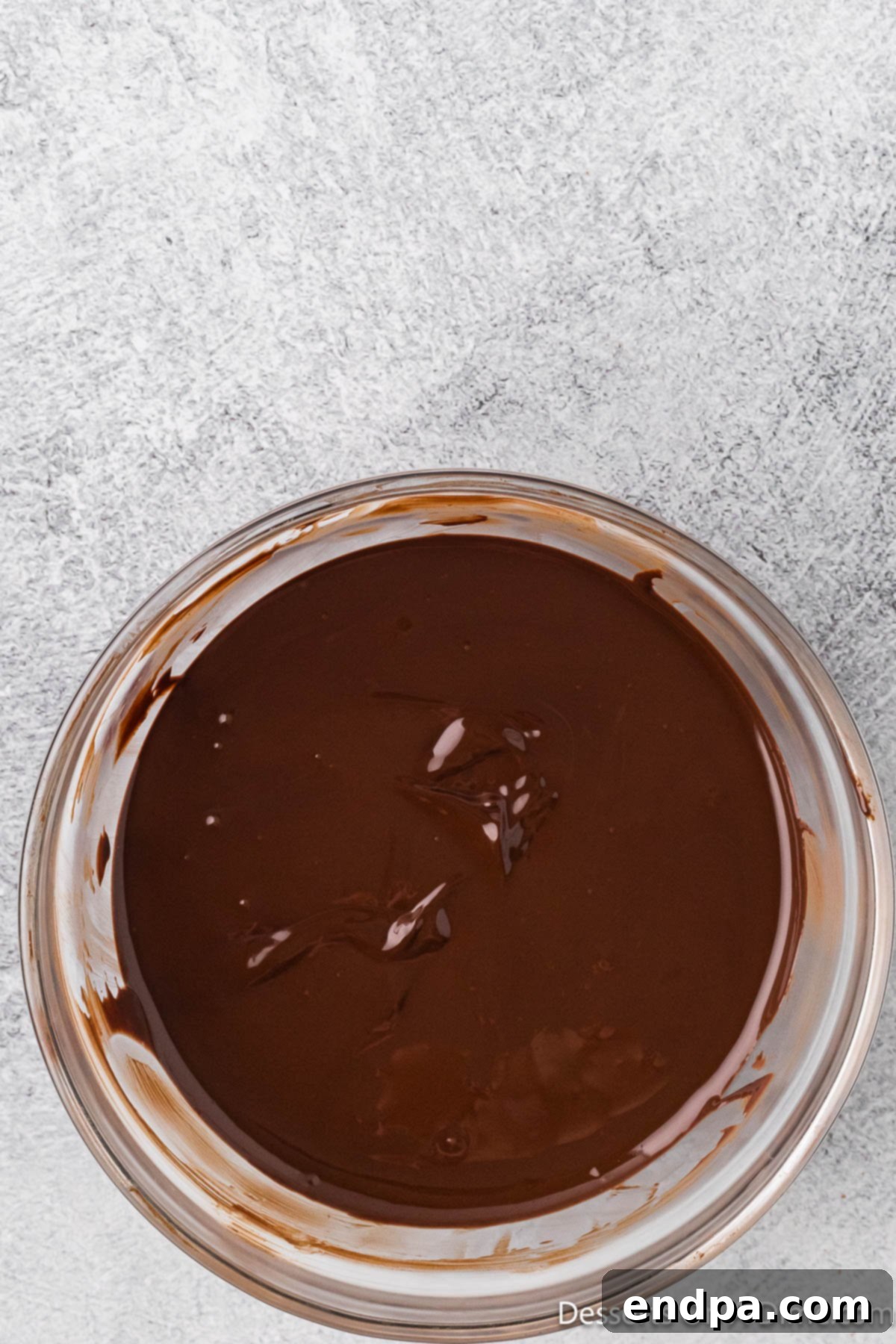 Bowl of melted semi-sweet chocolate, glistening and smooth.