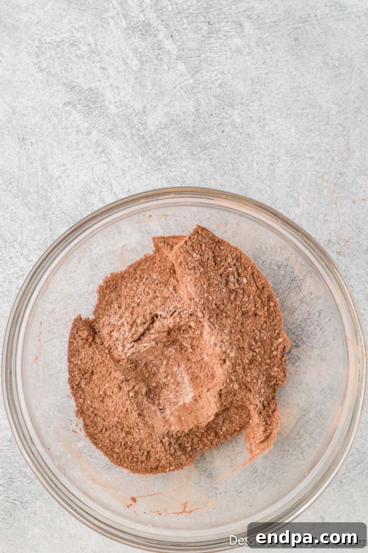 Dry ingredients, including flour, cocoa powder, baking powder, and salt, whisked together in a bowl.