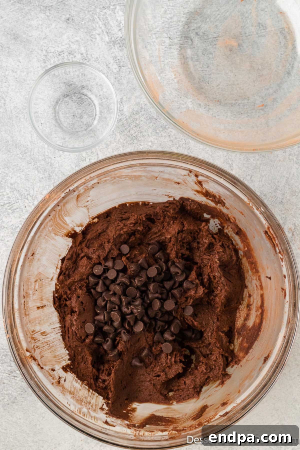 Semi-sweet chocolate chips being gently folded into the rich brownie batter.
