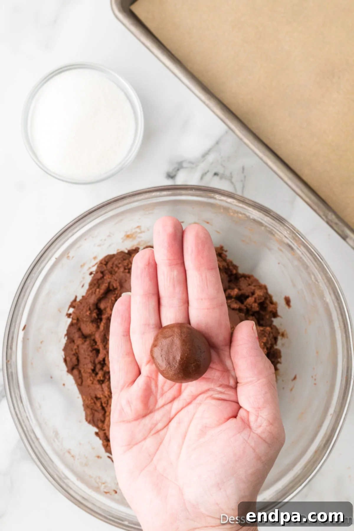 Small, uniform balls of chocolate cookie dough placed on a surface.
