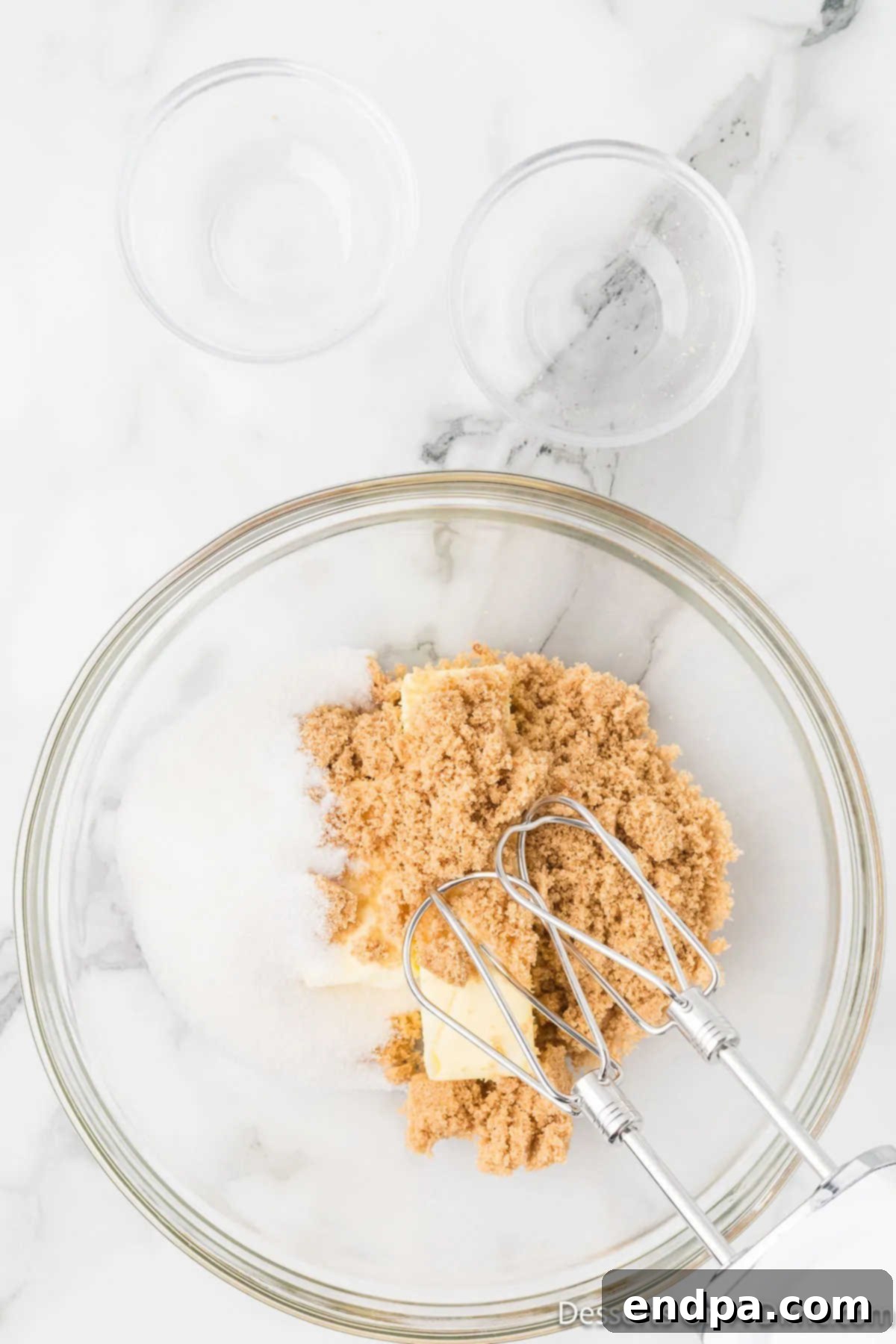 Softened butter, granulated sugar, and brown sugar combined in a mixing bowl.