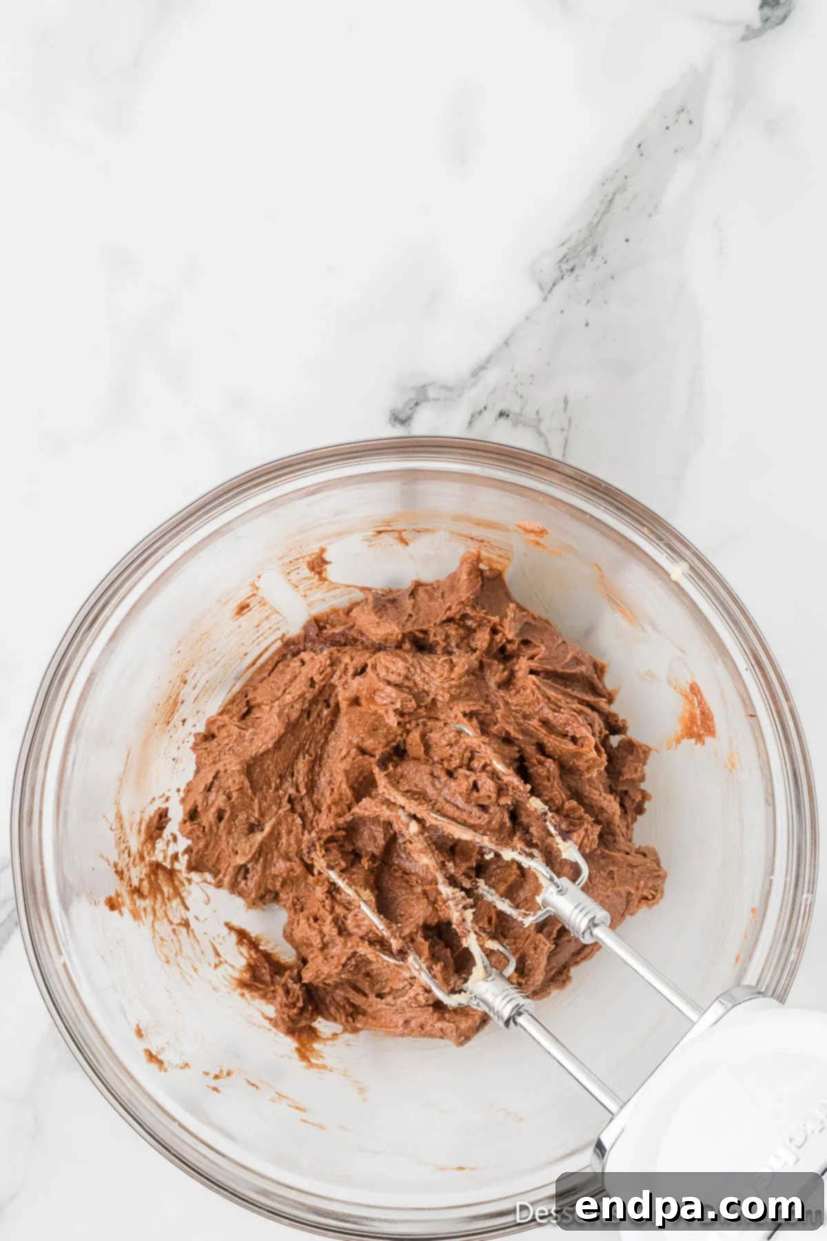 The wet ingredients, including cocoa powder, are now fully combined and mixed together in a bowl.