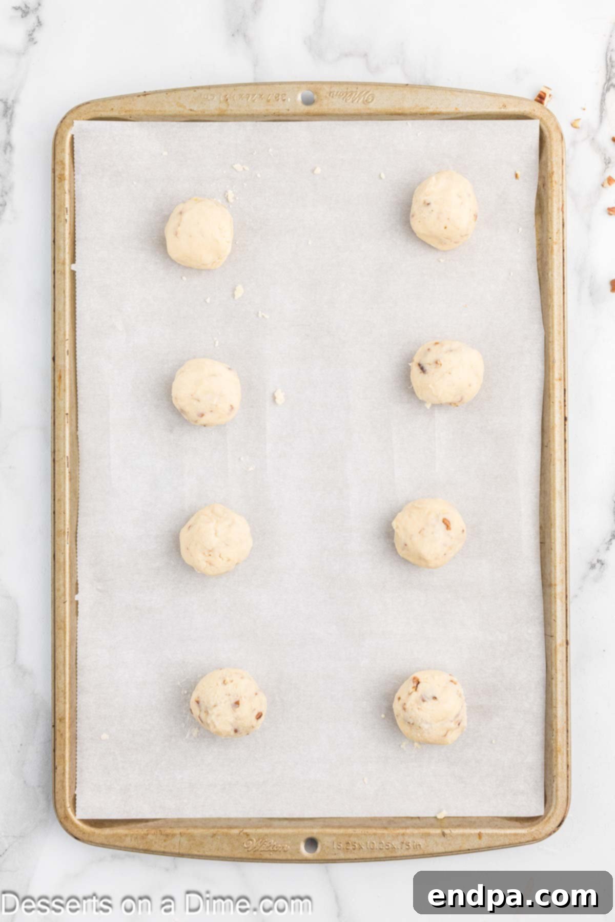 Powdered Sugar Dreams 8 Cookie dough rolled into balls and placed on a baking sheet.