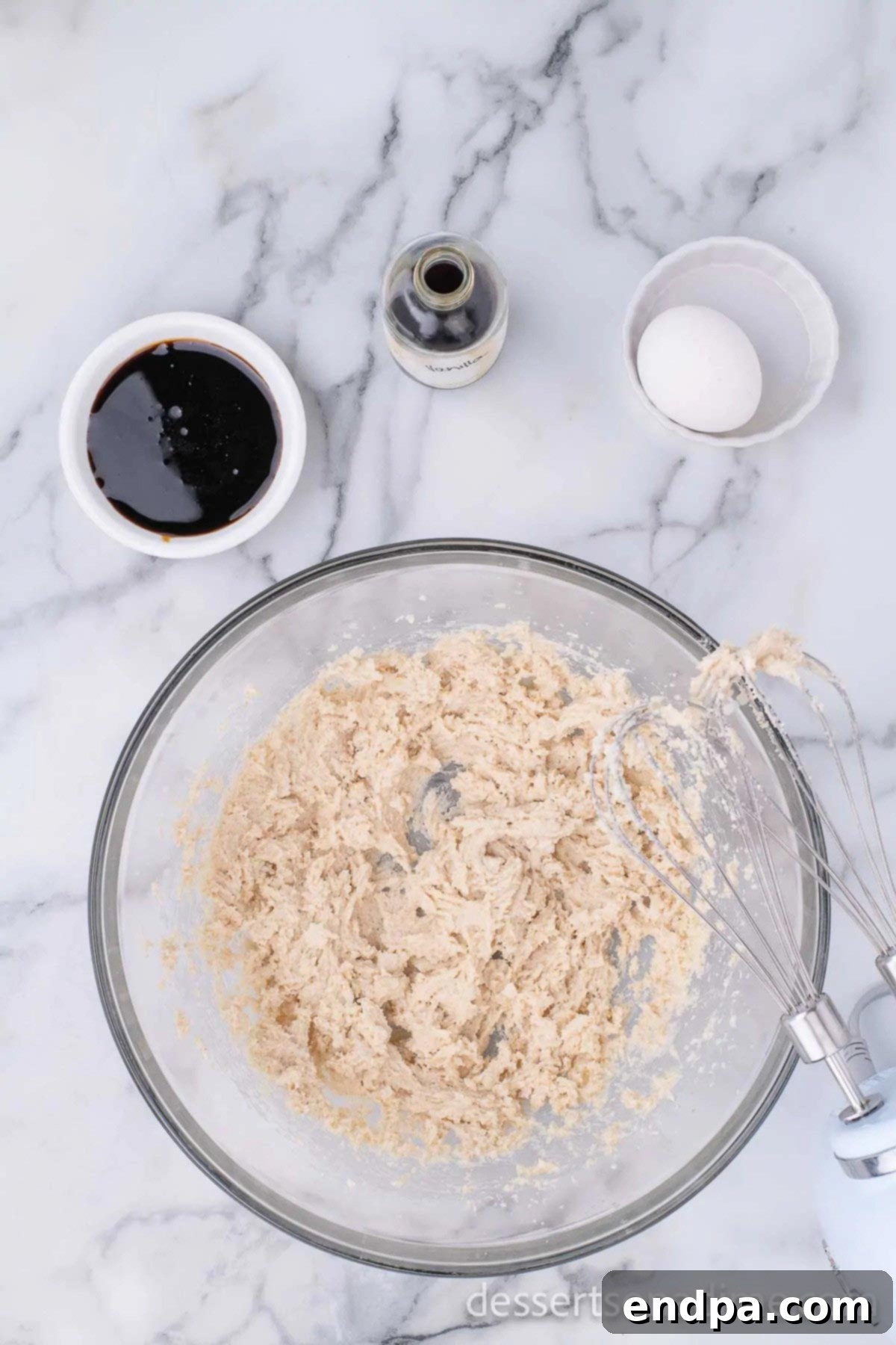 Molasses being added to the creamed butter and sugar mixture.