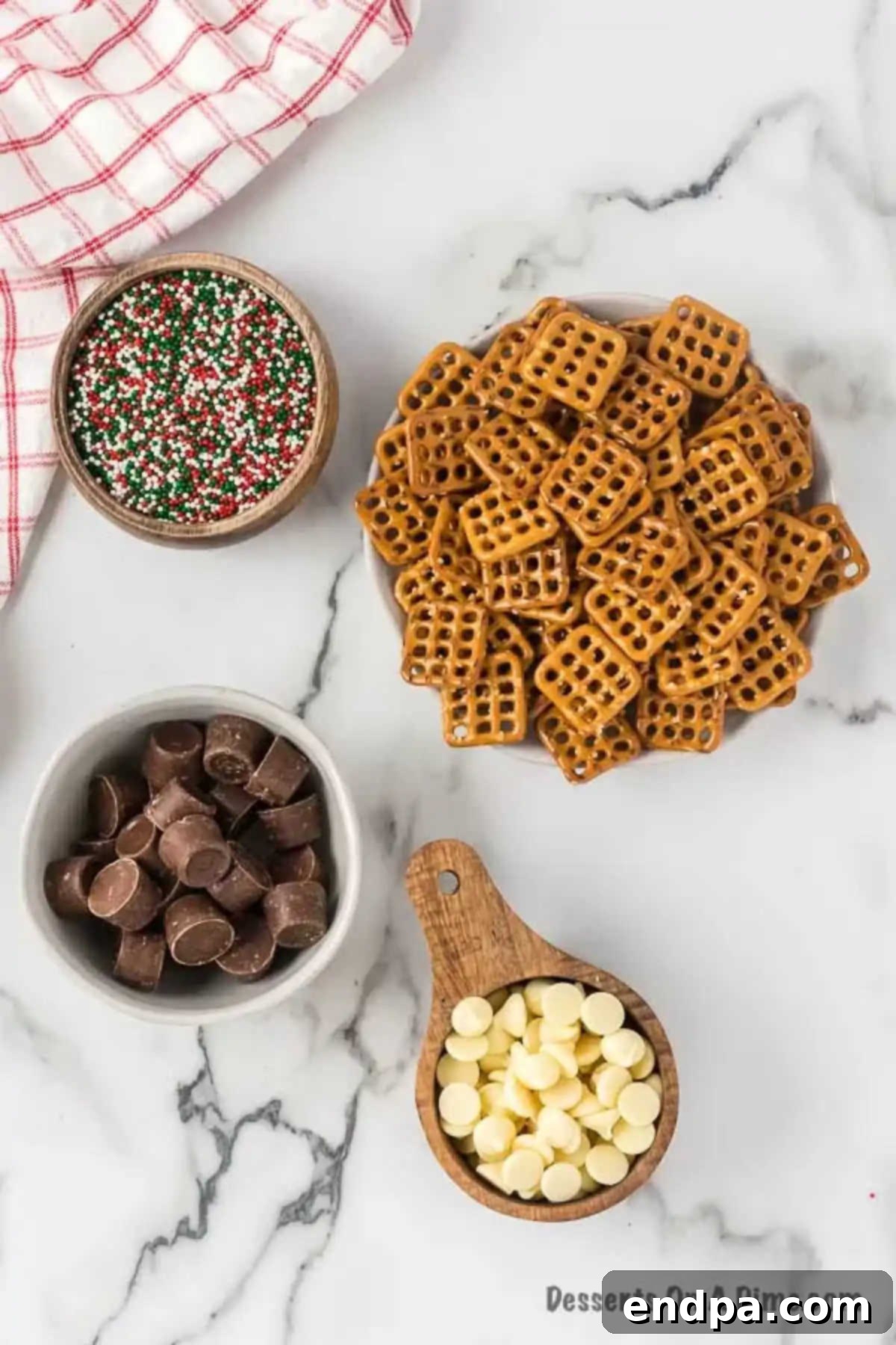 Ingredients for Rolo Pretzel Sandwiches - pretzels, rolo candy, sprinkles, white chocolate, neatly laid out.