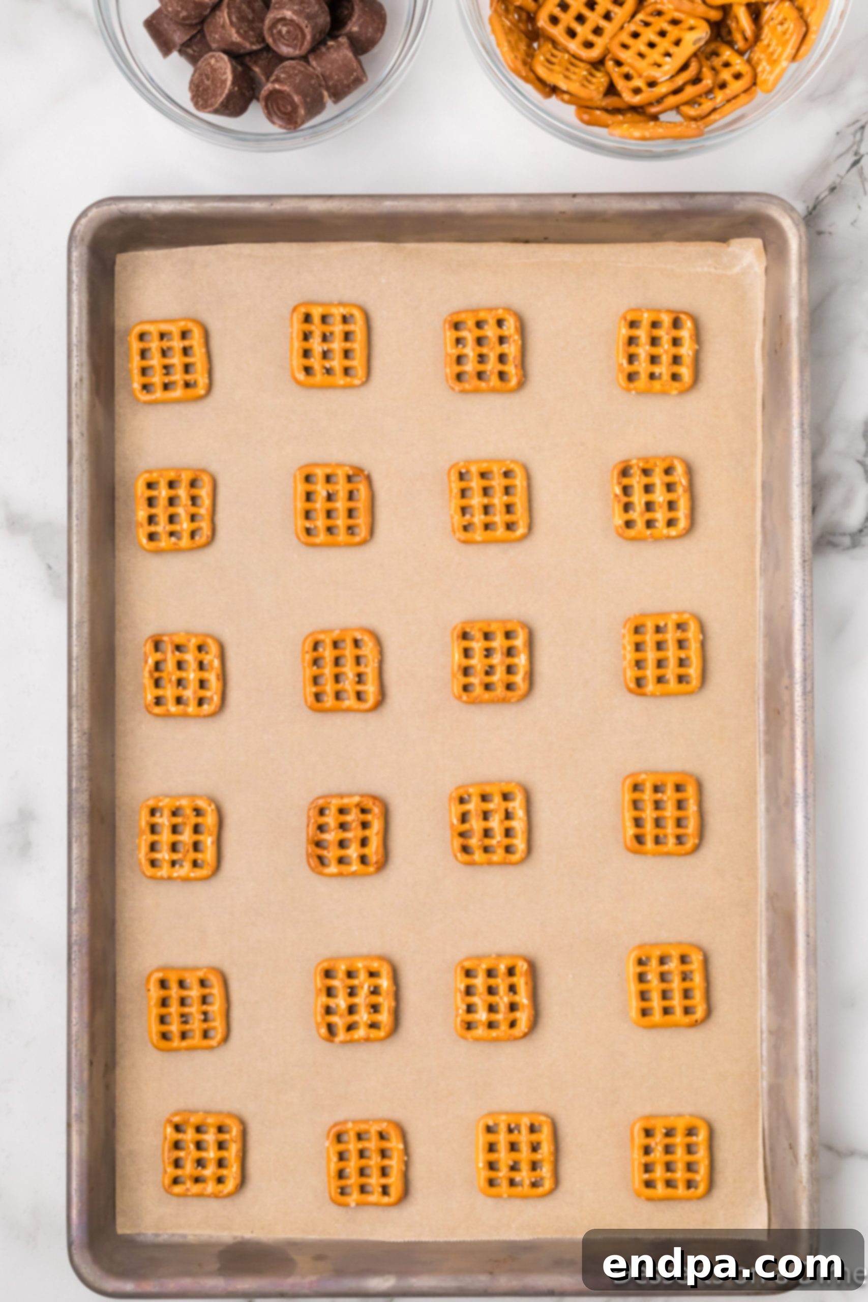 Pretzels neatly arranged on a baking sheet, ready for the oven.
