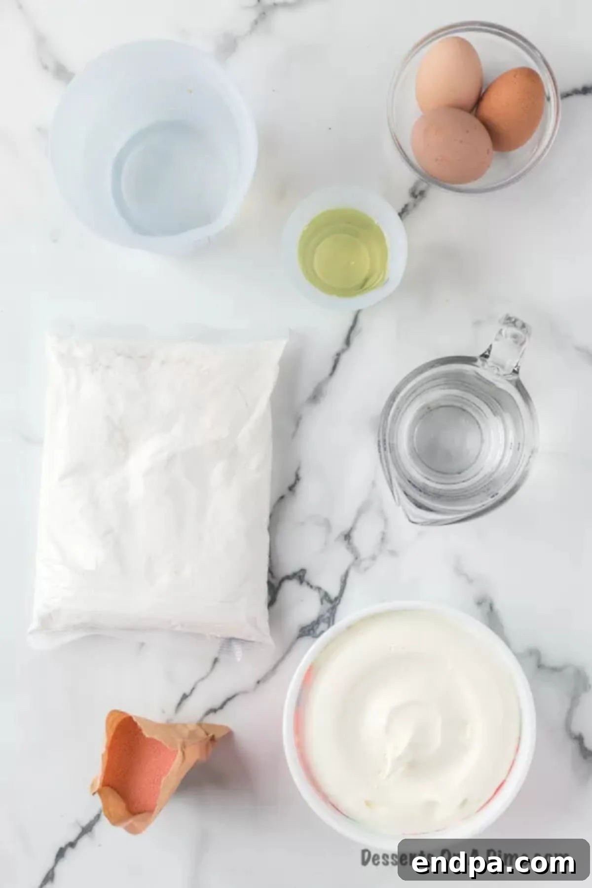 Ingredients for the Strawberry Poke Cake recipe laid out: eggs, oil, cake mix, jello, water, strawberries, and whipped topping.