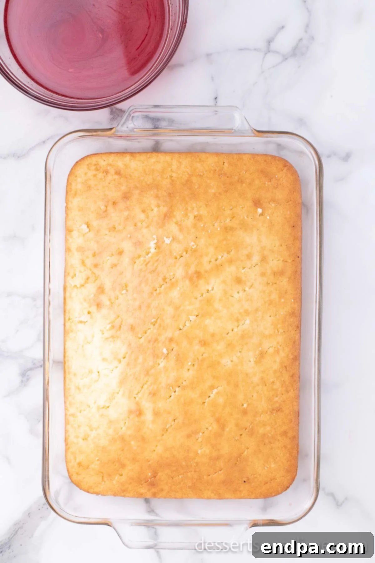 Close-up of a cake with holes poked across its surface.