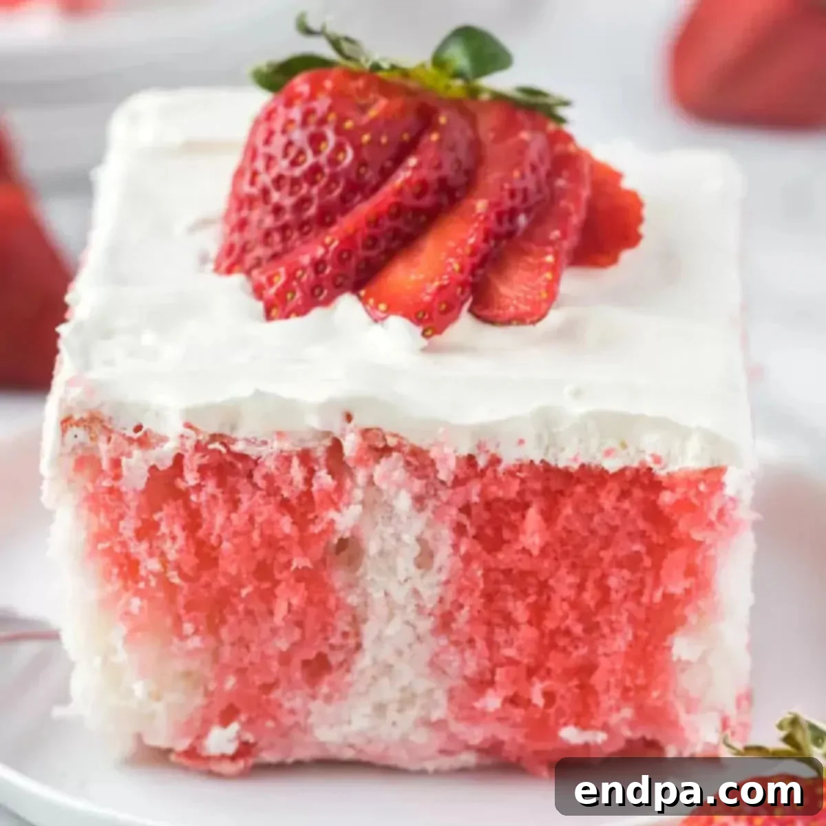 Strawberry Poke Cake, beautifully garnished with fresh strawberries and whipped cream.