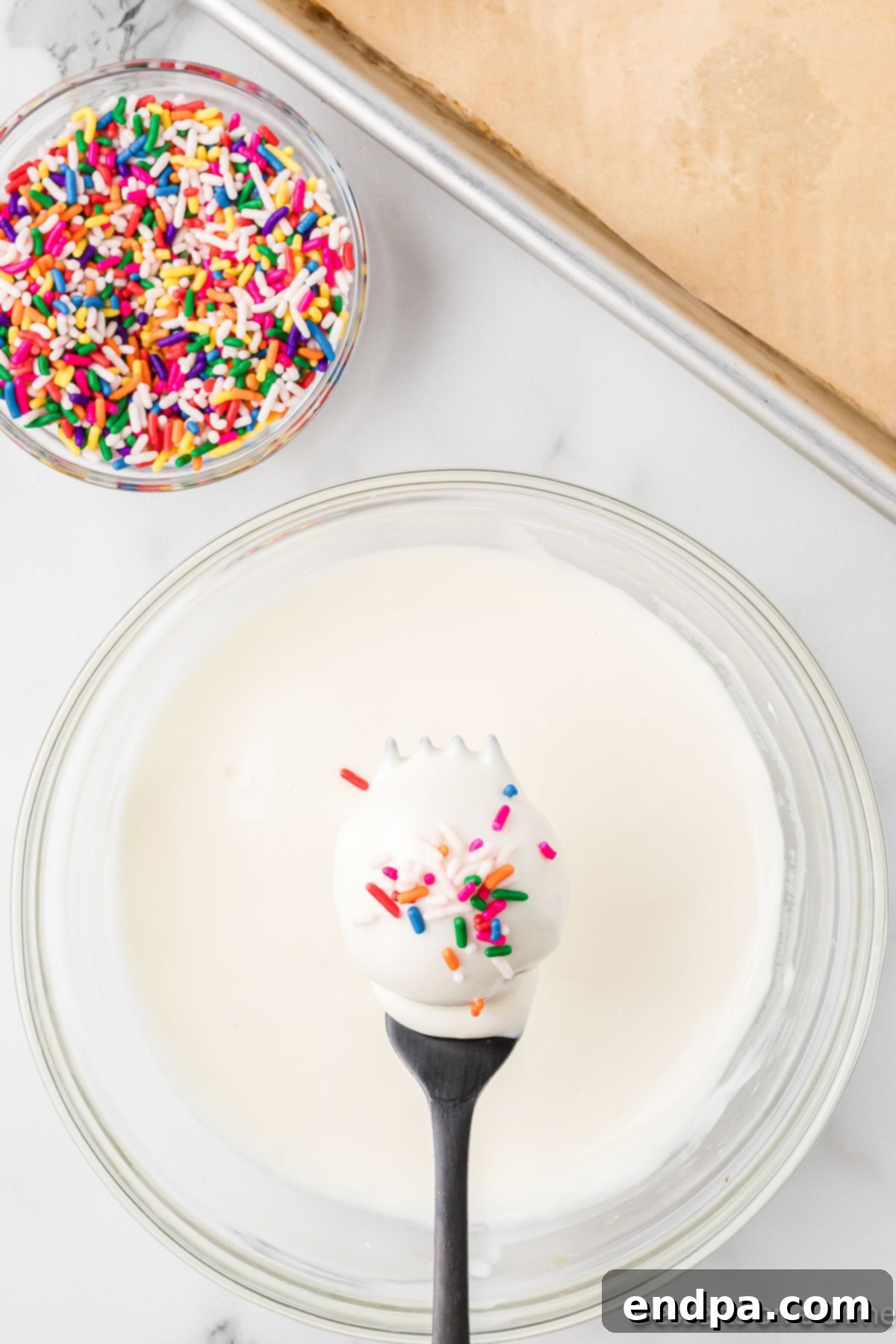 Vanilla cake balls covered in sprinkles, freshly dipped.