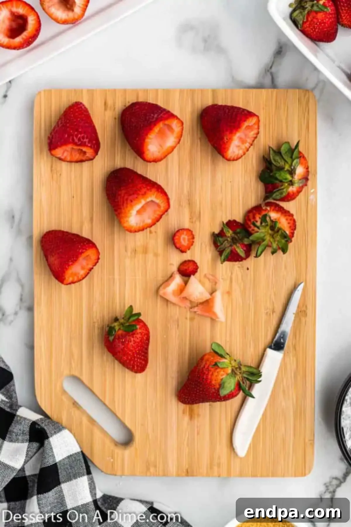 Strawberries being cleaned, destemmed, and hollowed out for stuffing.