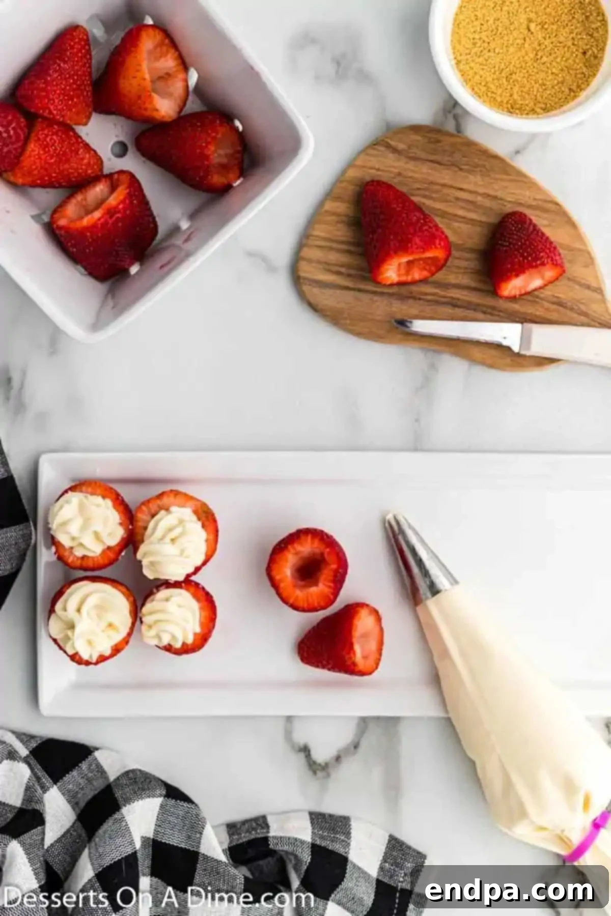 Cheesecake filling being piped into hollowed strawberries and arranged on a serving platter.