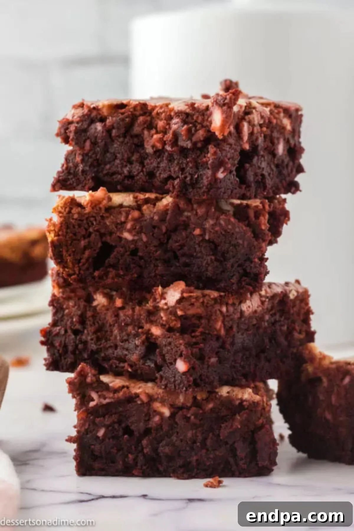 Swirled Red Velvet Cheesecake Brownies 2 Red velvet cheesecake brownies stacked together, showcasing rich red and creamy white swirls.