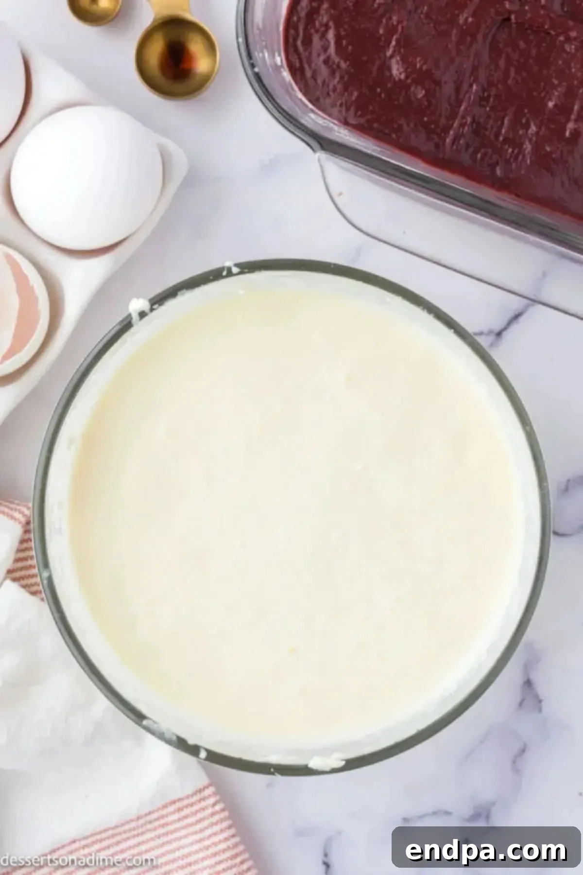 Swirled Red Velvet Cheesecake Brownies 6 Cheesecake mixture combined in a bowl, showing its smooth and creamy texture.