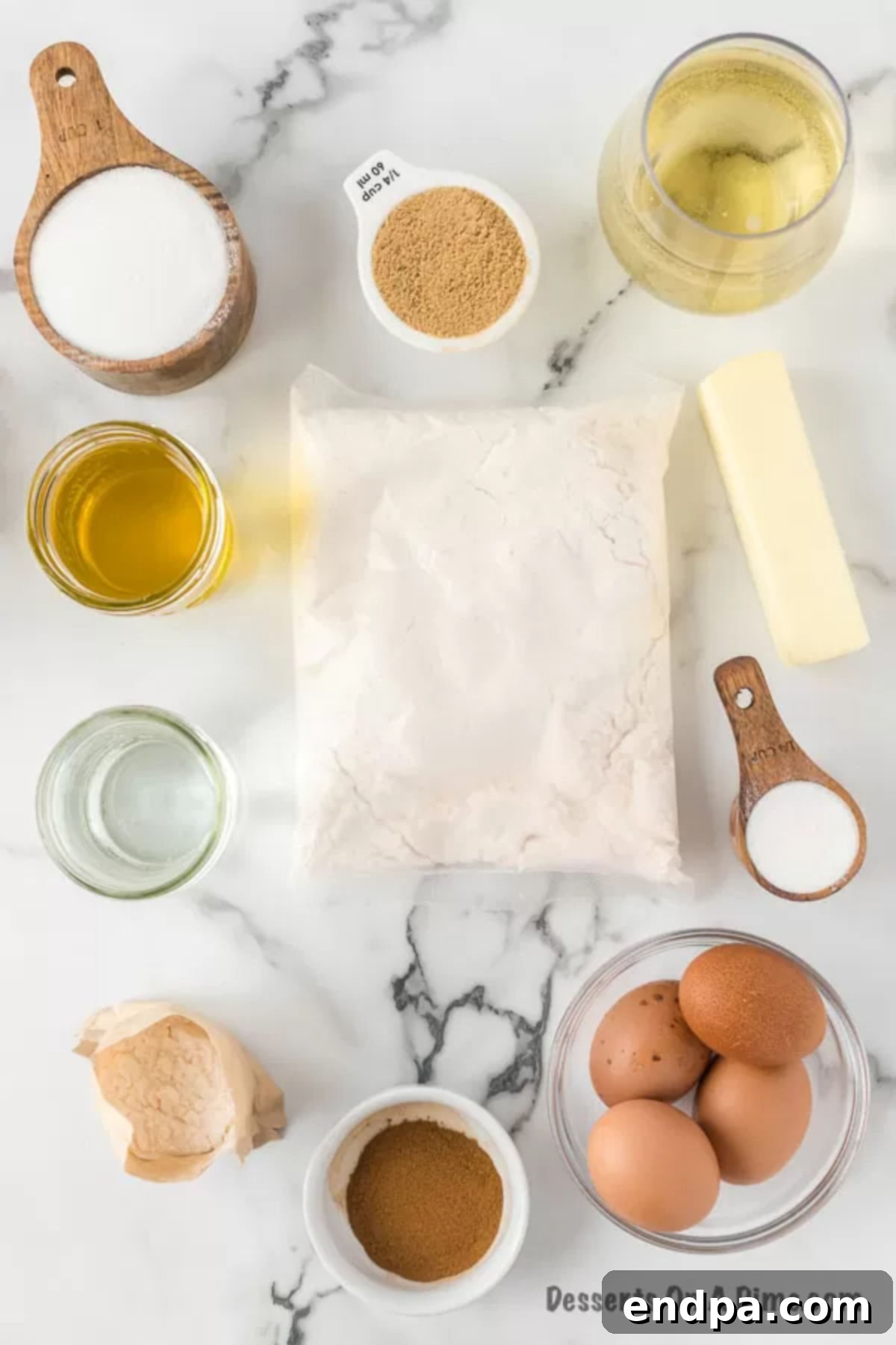 Unforgettable Craving Cake 3 A flat lay photograph displaying all the ingredients required for Crack Cake: yellow cake mix, instant vanilla pudding, brown sugar, granulated sugar, cinnamon, large eggs, water, vegetable oil, and white wine for both the cake and glaze, alongside butter.