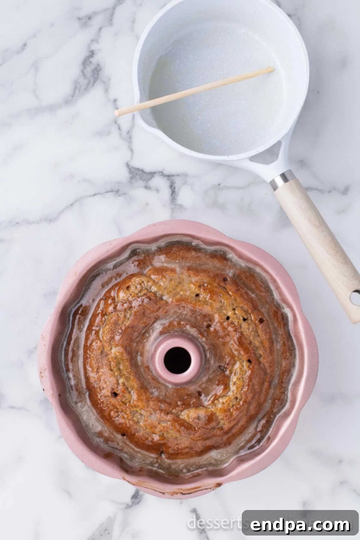 Unforgettable Craving Cake 7 Image demonstrating pouring the warm white wine glaze over the freshly baked, hot Bundt cake still in its pan.