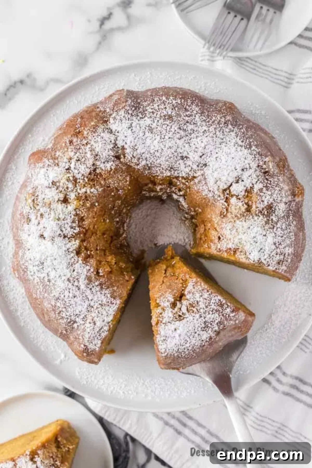 Unforgettable Craving Cake 8 A beautiful slice of Crack Cake presented on a serving plate, showcasing its golden color and glossy glaze, adorned with fresh berries and a sprig of mint.
