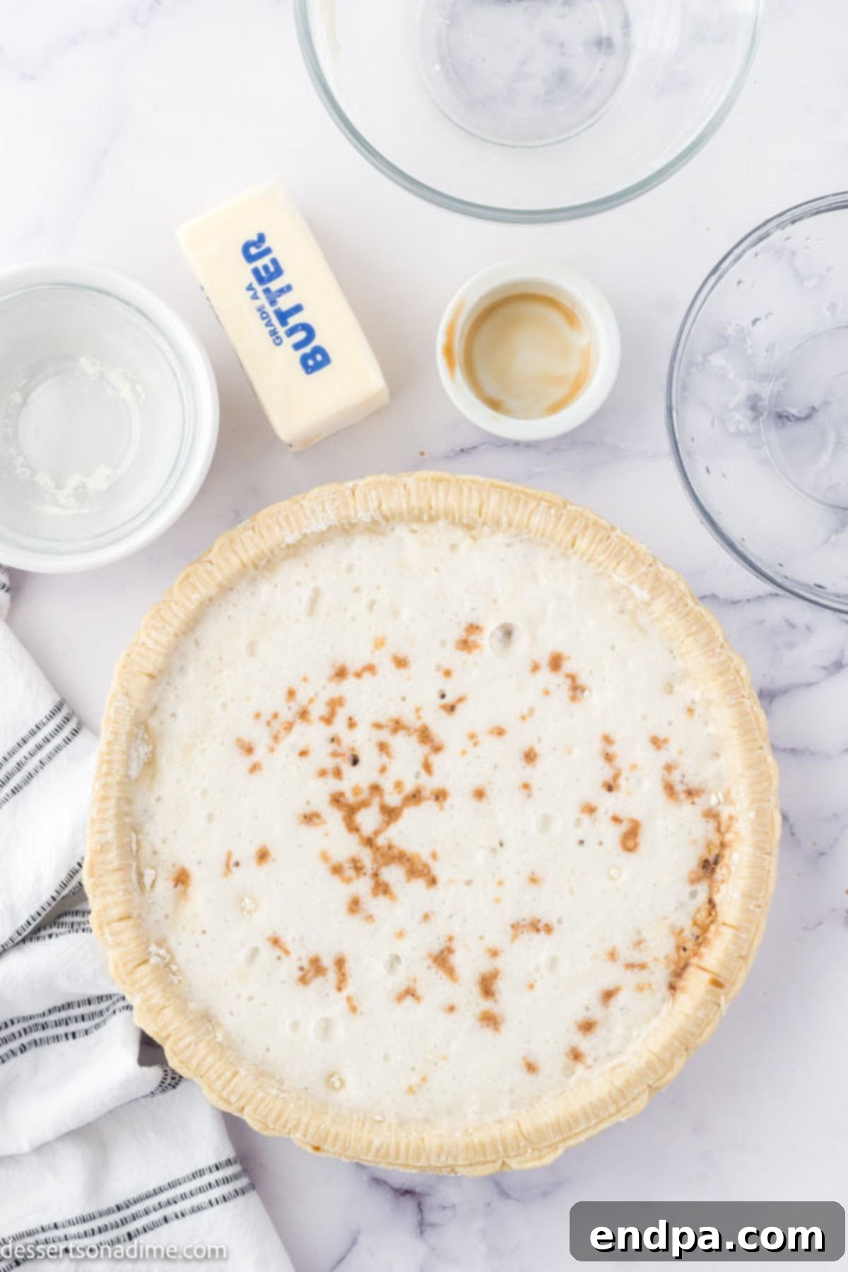 Vanilla extract being drizzled or sprinkled over the sugar, flour, and Sprite mixture in the pie crust.