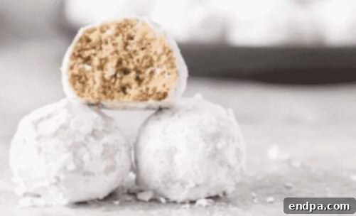Delicate Snowball Cookies, generously coated in powdered sugar, arranged on a plate.