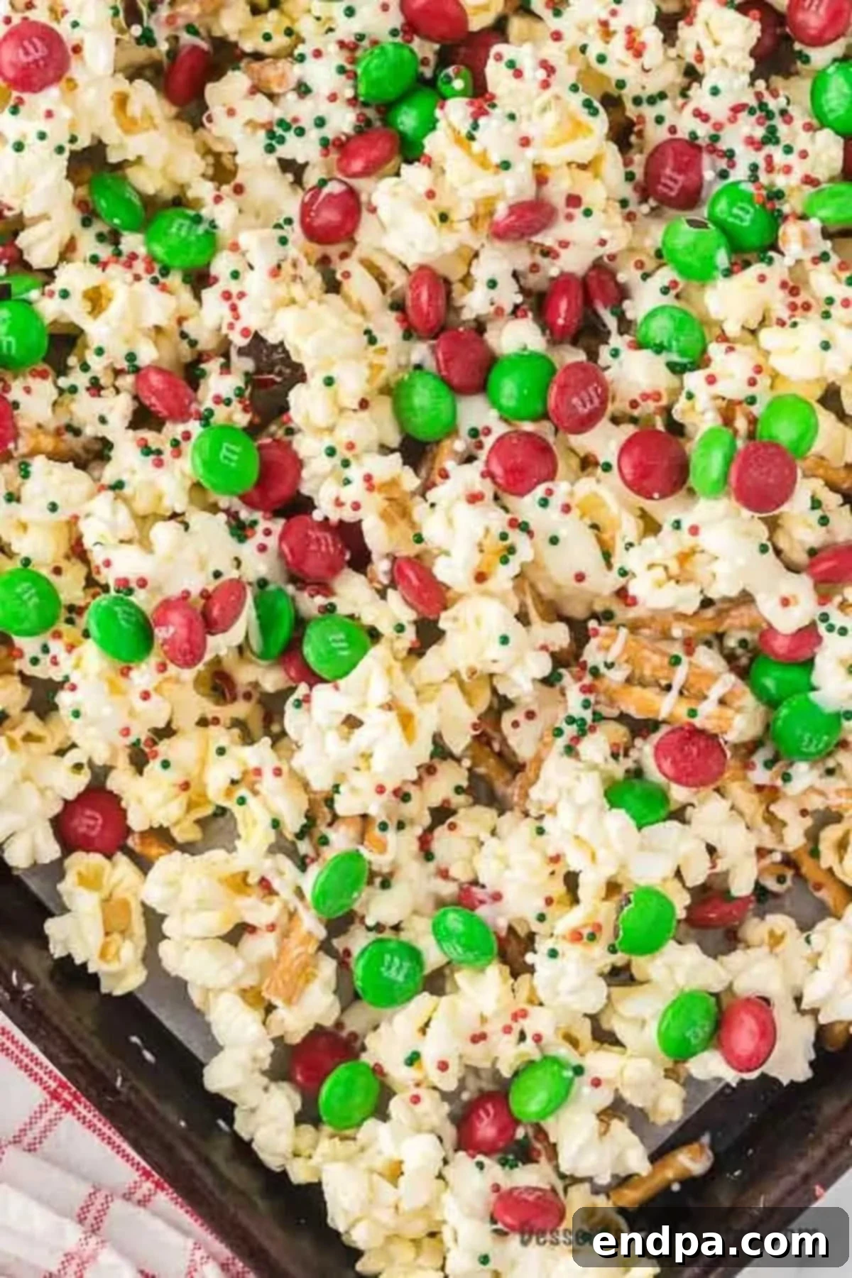 A close-up shot of Christmas Crunch spread on a baking sheet, showcasing the festive colors and textures.