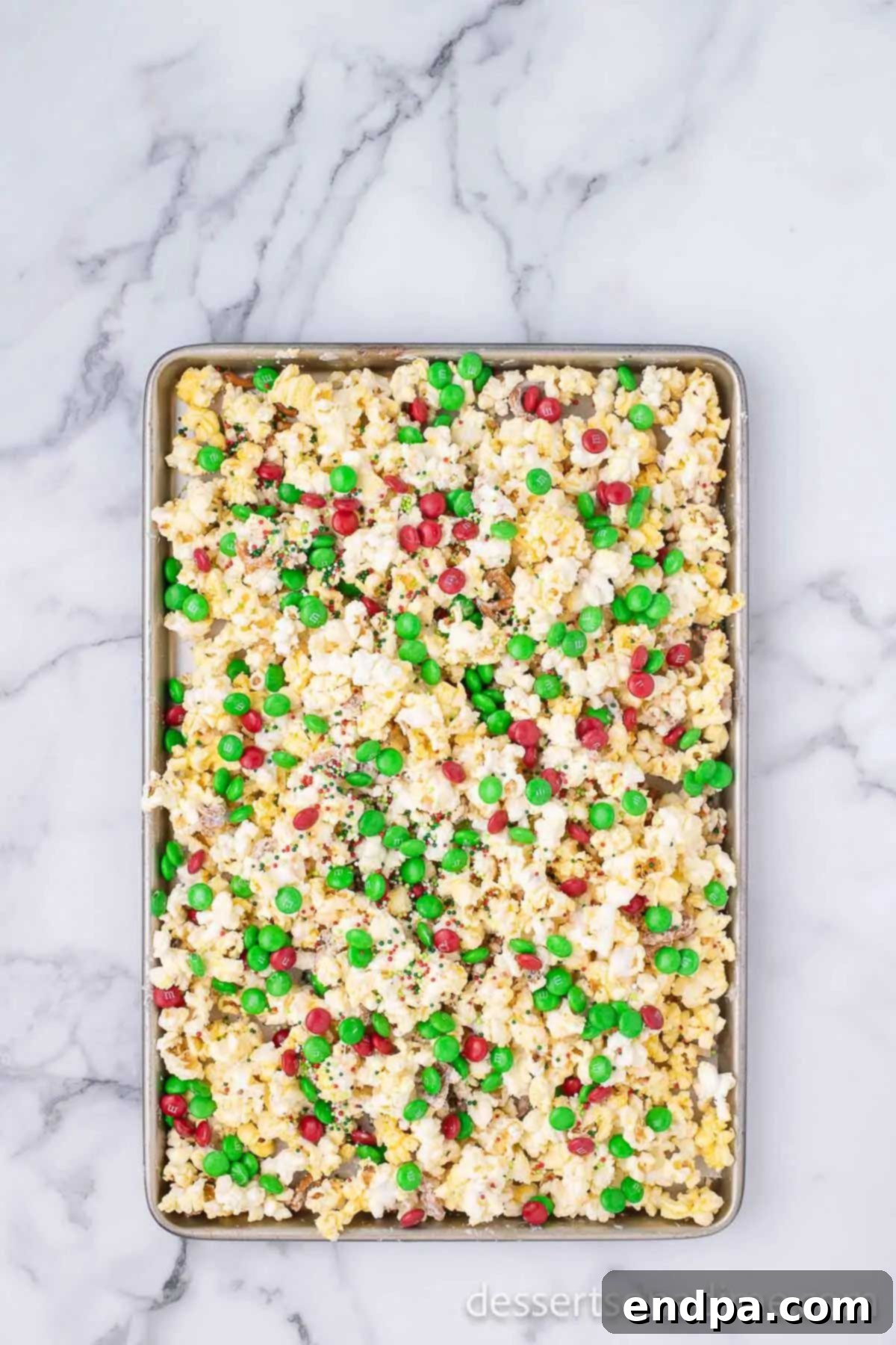 Christmas Crunch mixture spread out on a baking sheet, cooling and hardening.