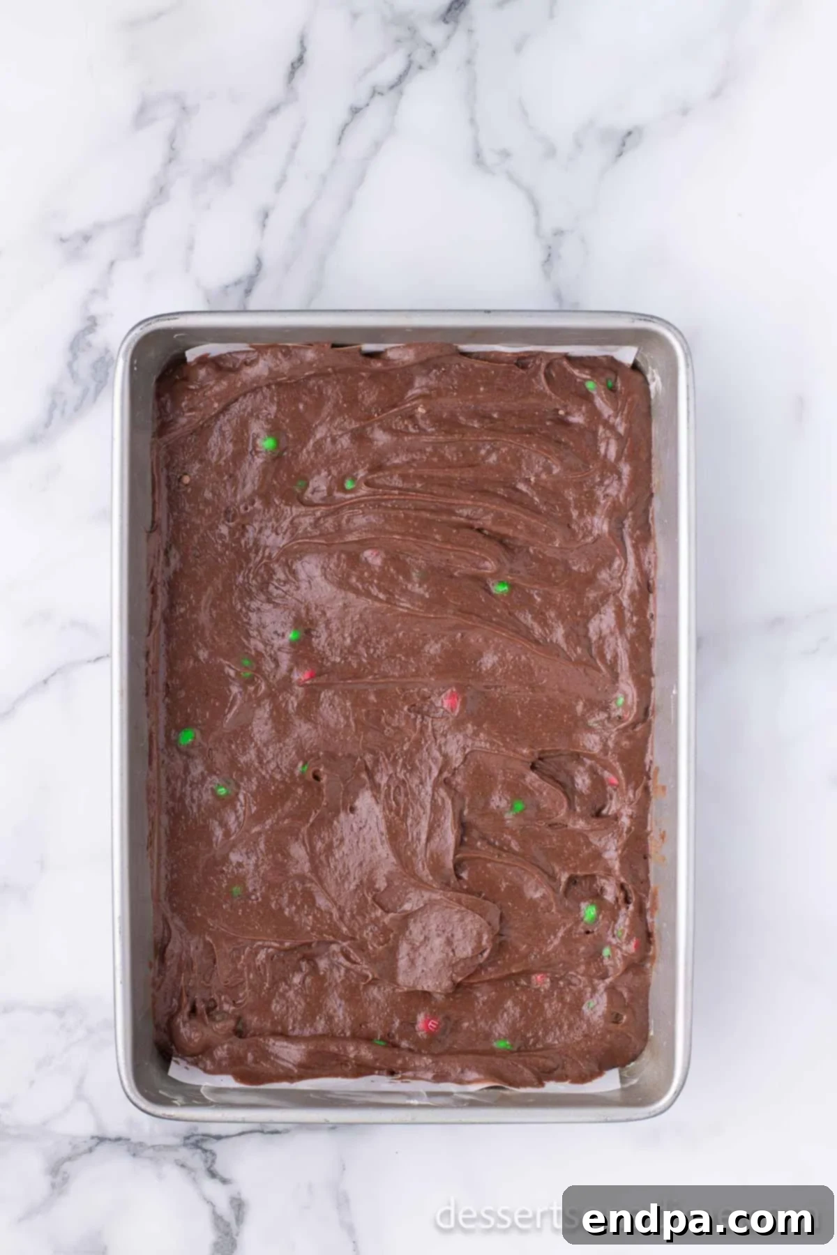 Merry & Bright Brownies 7 Brownie batter spread evenly in a baking pan, ready for the oven.