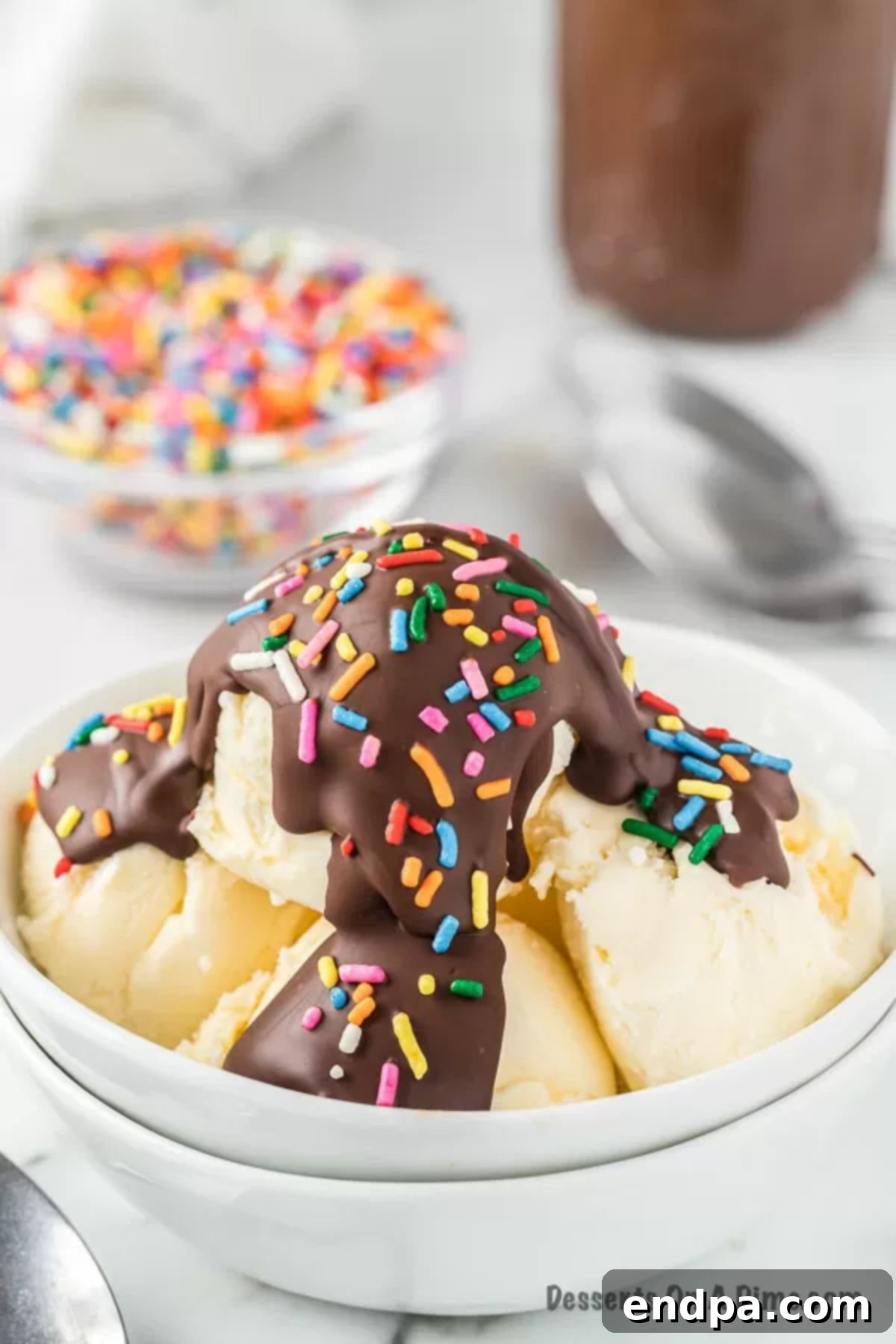 Homemade Hardening Chocolate Topping 2 Ice cream in a white bowl with magic shell on top, ready to be enjoyed.