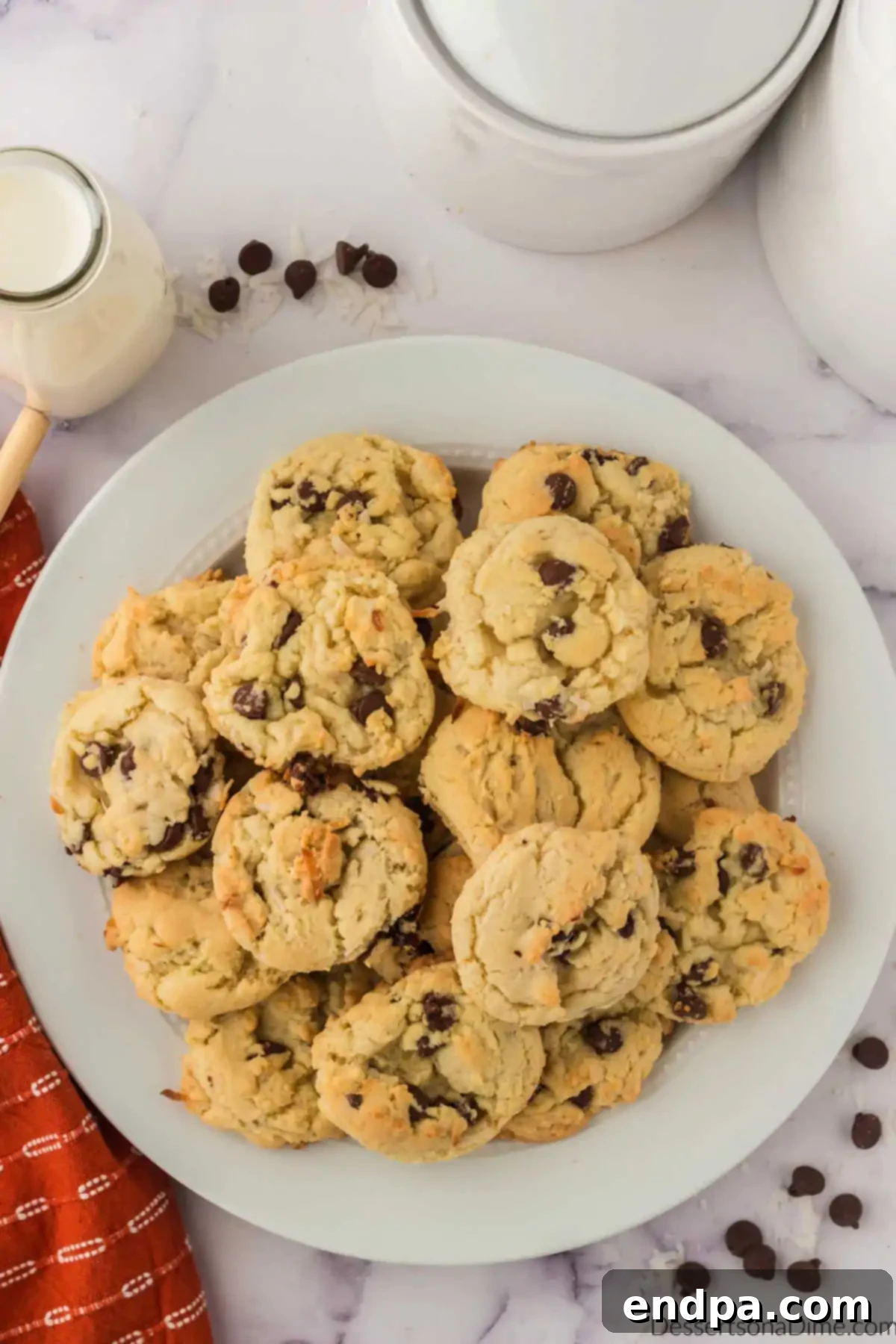 Chewy Coconut Chocolate Chip Dreams 4 Freshly baked coconut chocolate chip cookies on a plate, ready to be enjoyed.