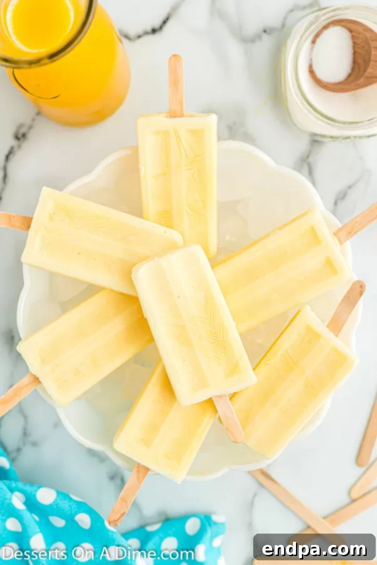 Orange Vanilla Swirl Pop 2 Orange creamsicle popsicles on a platter.