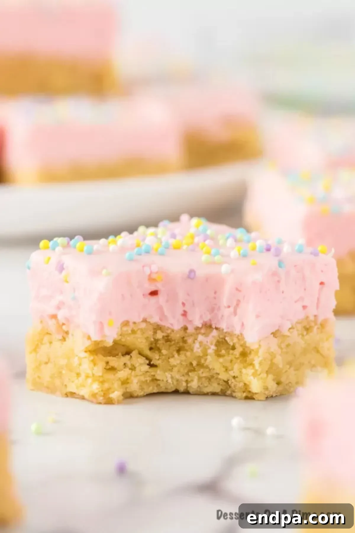 Perfectly Soft Sugar Cookie Bars 11 Close-up of a perfectly frosted sugar cookie bar, highlighting its soft texture and colorful sprinkles.