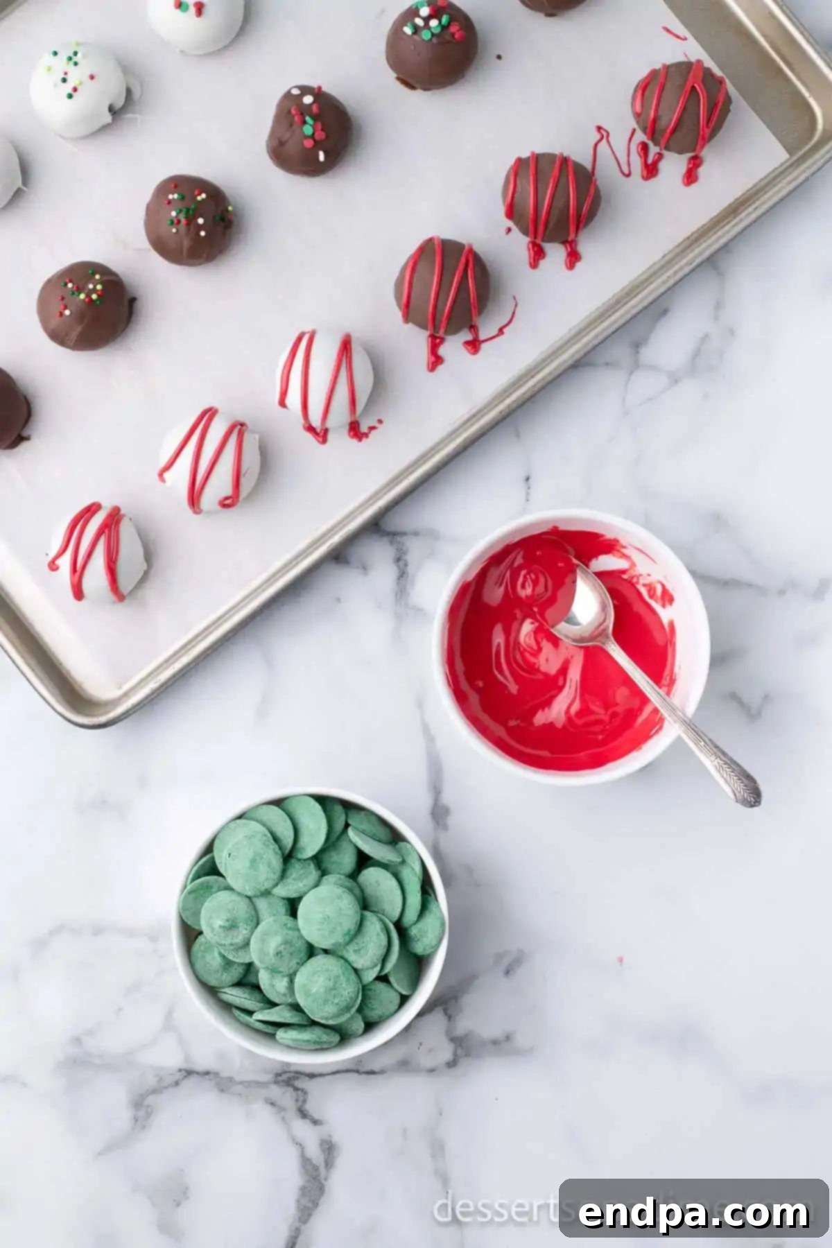 Irresistible Holiday Oreo Truffles 11 Melted green and red candy melts are shown in separate bowls, ready to be drizzled over the Christmas Oreo truffles.