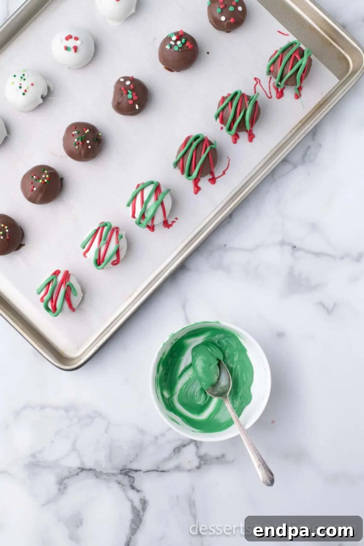 Irresistible Holiday Oreo Truffles 12 Christmas Oreo truffles are artfully drizzled with contrasting red and green candy melts, creating a festive pattern.
